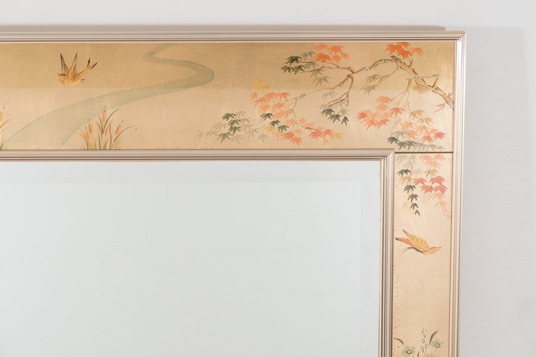 A vintage beveled wall mirror in the chinoiserie style, originally designed by LaBarge circa 1970's, inset in a reverse hand-painted églomisé border, decorated with cherry blossoms, butterflies and foliage motif, within an anodized aluminum frame.