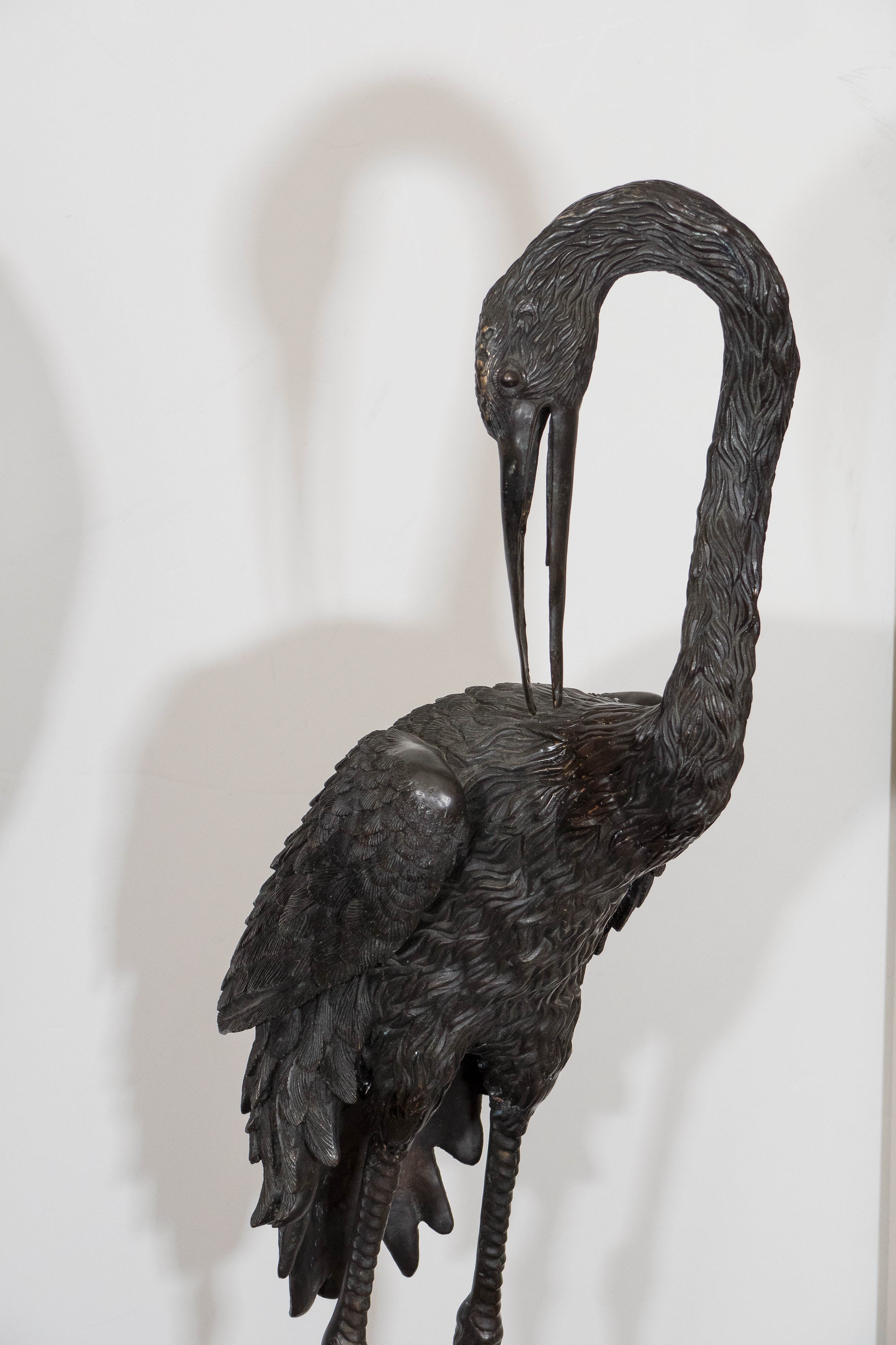 A pair of contemporary, intricately detailed sculptural cranes, each standing on turtles, in solid patinated bronze. Very good condition, consistent with age.

Dimensions of Left Crane (Neck Extended): 18