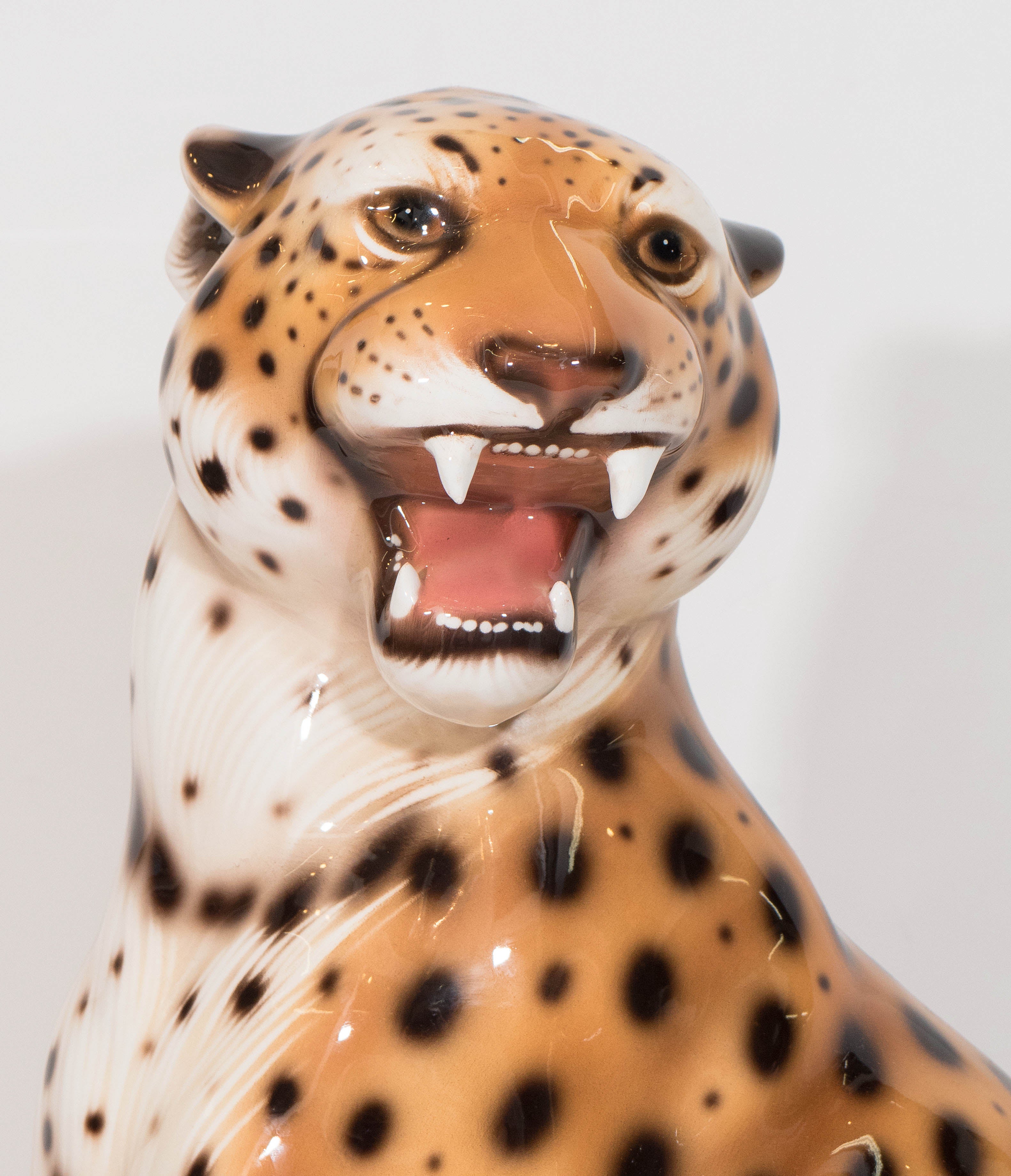 An Italian vintage sculptural leopard, produced circa 1960s, in glazed ceramic, depicted sitting upright, roaring ferociously. Markings include stamp [Made in Italy] on the base. Good vintage condition, with minor age appropriate wear to the base.