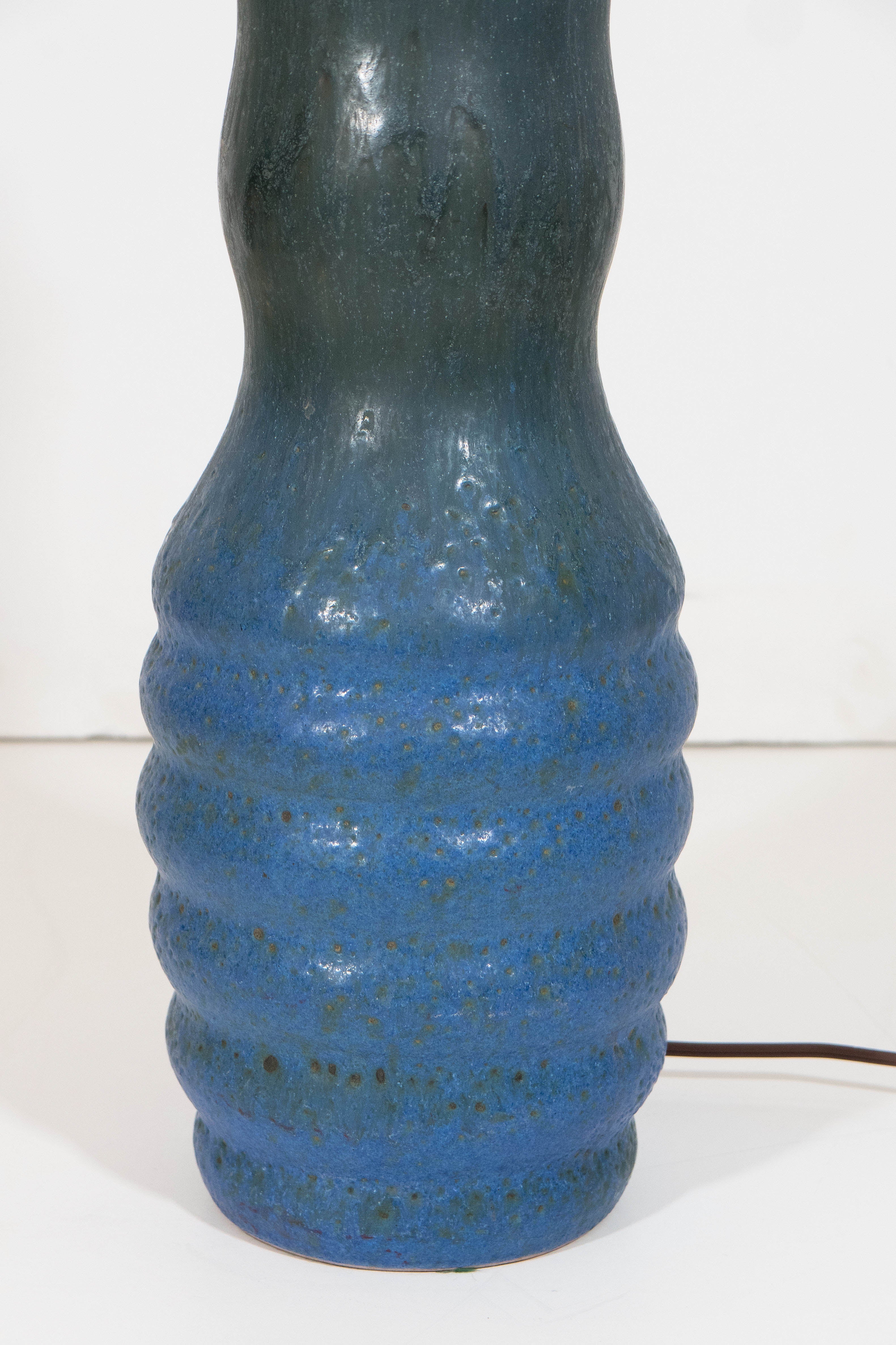 A vintage ceramic ribbed and gourd form pottery lamp, produced in Italy, circa 1960s for Raymor, with matte glaze in green and blue; brass harp and finial included. Wiring and socket to US standard, requires a single Edison base bulb. Markings