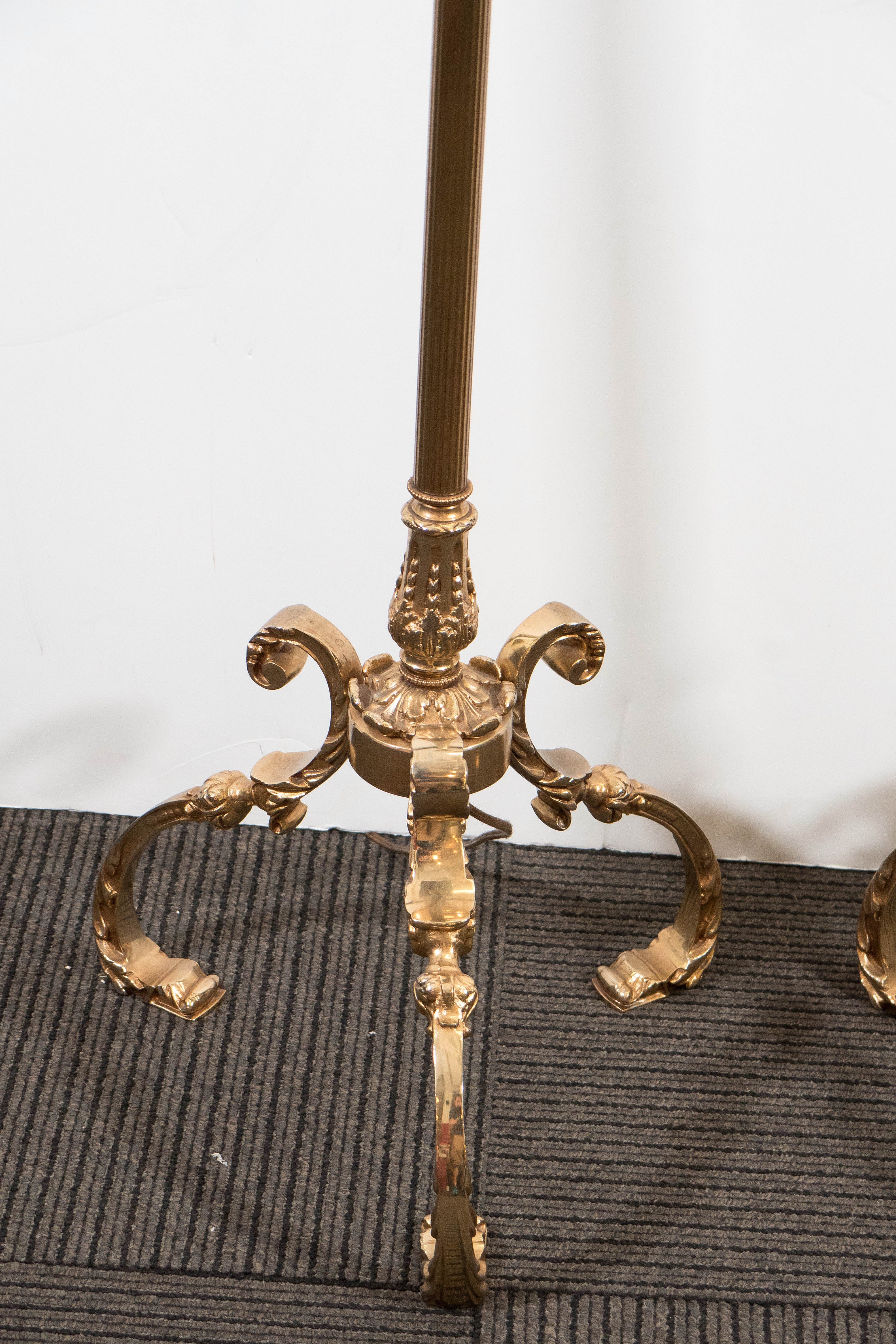 A pair of vintage, Hollywood Regency brass floor lamps, produced by the Marbro Lamp Company of Los Angeles, California, with double cluster sockets (each with pull chain), over reeded, classically styled stem, with decorative acanthus bobeche and
