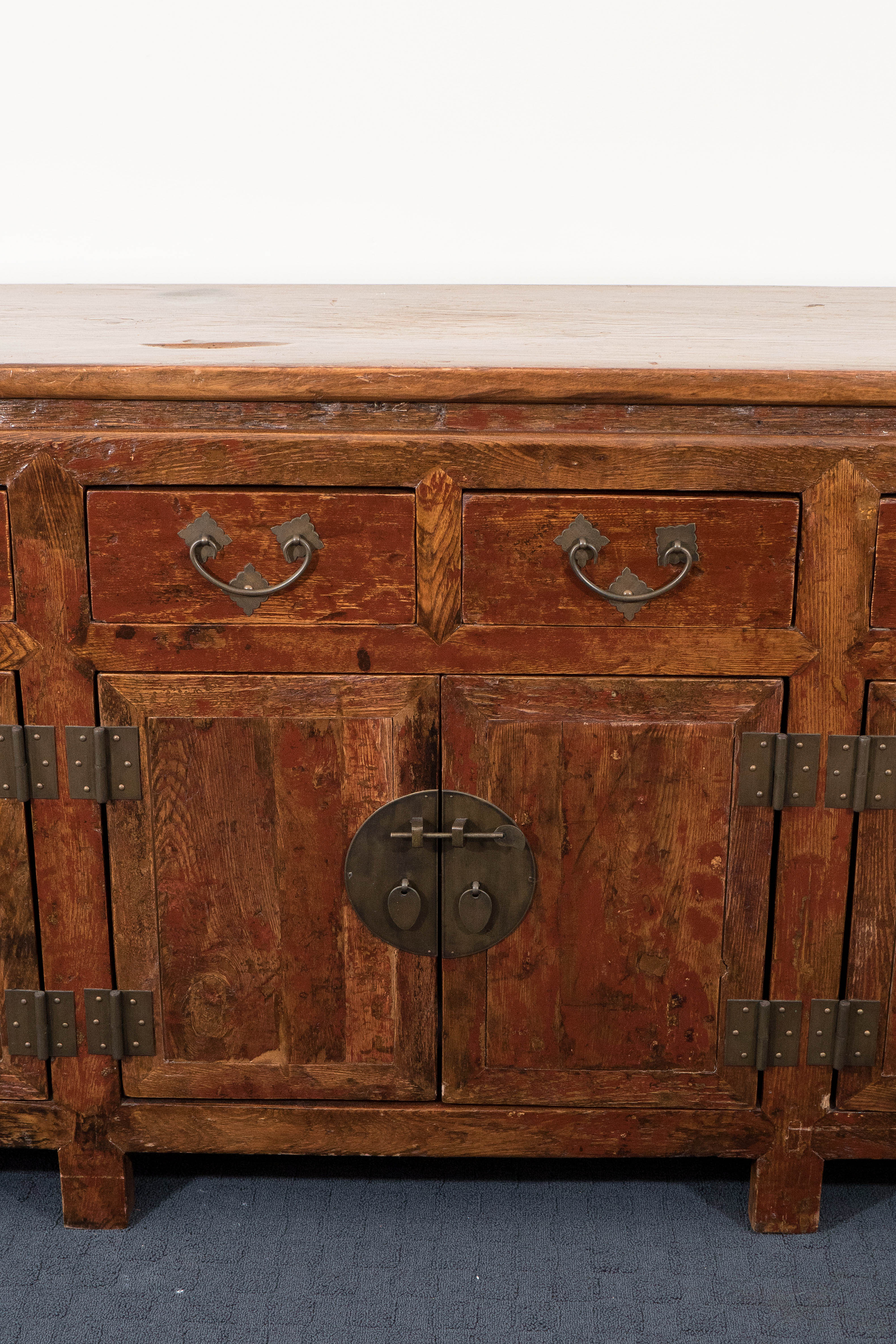 An antique wooden buffet and sideboard, originating from Tianjin, mainland China, produced circa mid to late 19th century, which includes six exterior drawers, above three sets of double doors, with handles, pulls and latch keys in brass. Good