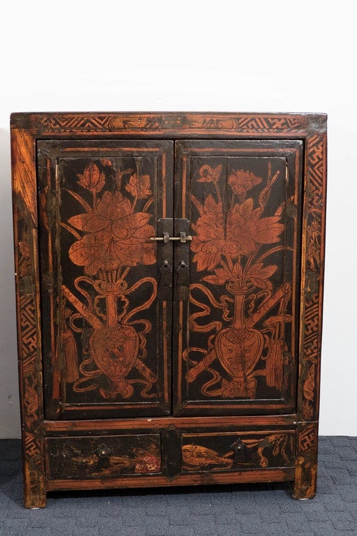 A pair of antique black lacquer and gilt-painted wood cabinets, originating from mainland China, produced circa 18th century, each with two doors, including metalwork handles and latch keys, the interior space inset by single central shelf, above