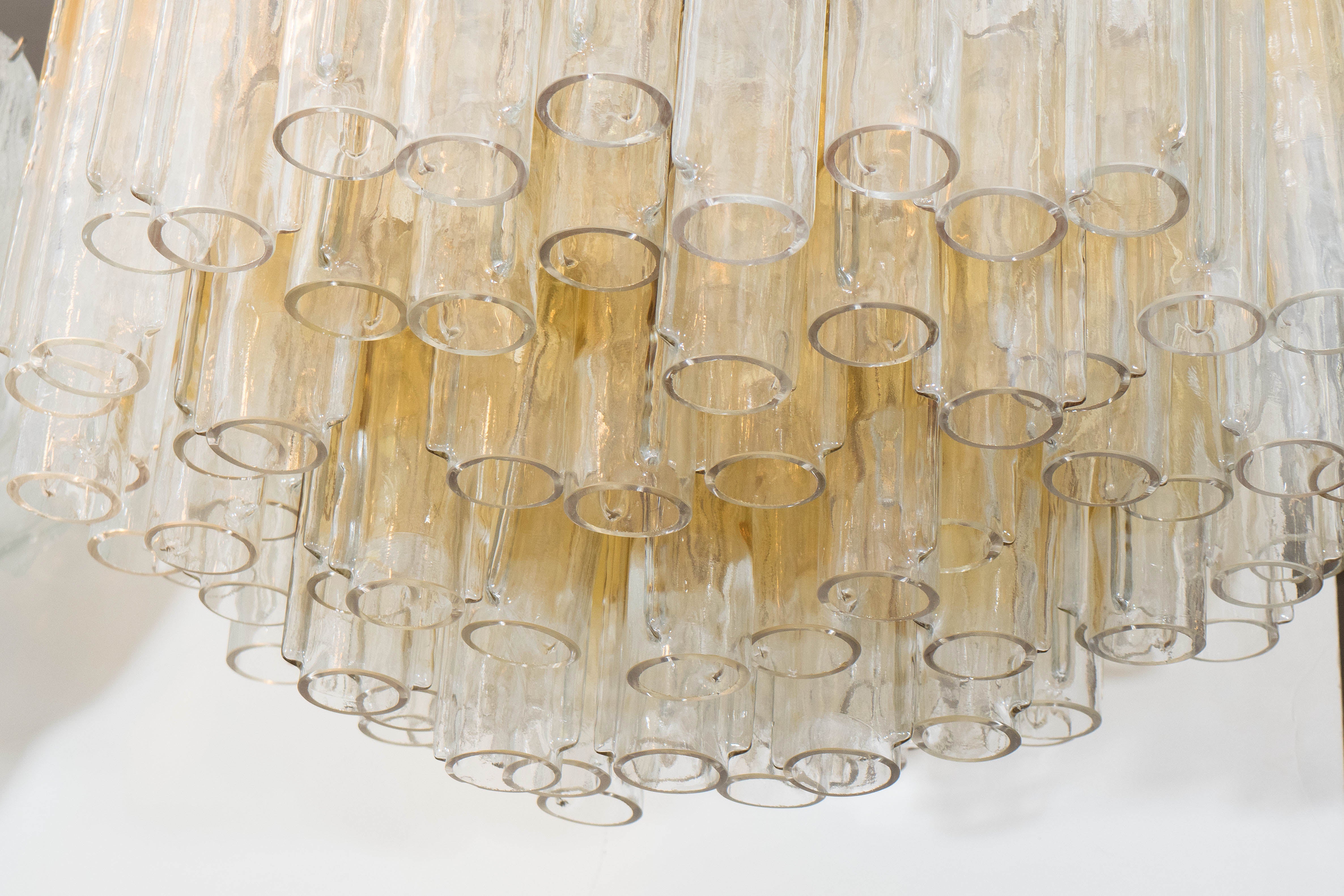 An Italian vintage, large scale Murano glass chandelier, produced circa 1960's by Venini, decorated with glass tubes, in golden yellow to clear ombre. Markings include stamp, [Venini/Murano/Made in Italy] affixed to the top of the frame. Requires