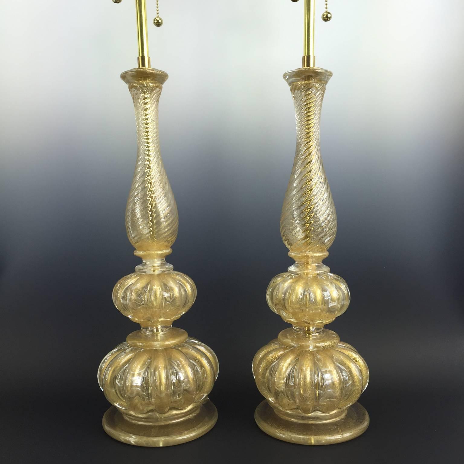 An exquisite pair of vintage, hand-blown Murano glass lamps, produced circa 1940’s by Barovier and Toso, each with double cluster sockets (pull chains included), over glass baluster form body with gadrooned bulbs, the fluted parts of the lamps