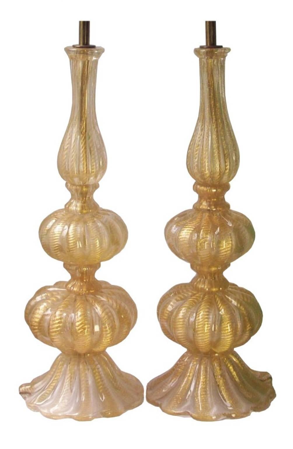 A pair of vintage Venetian hand-blown Murano glass table lamps, produced circa 1950s by Barovier and Toso, each with single sockets in brass hardware over gadrooned baluster form bodies, with 'cordonato d'oro' gold leaf infusions. Very good vintage