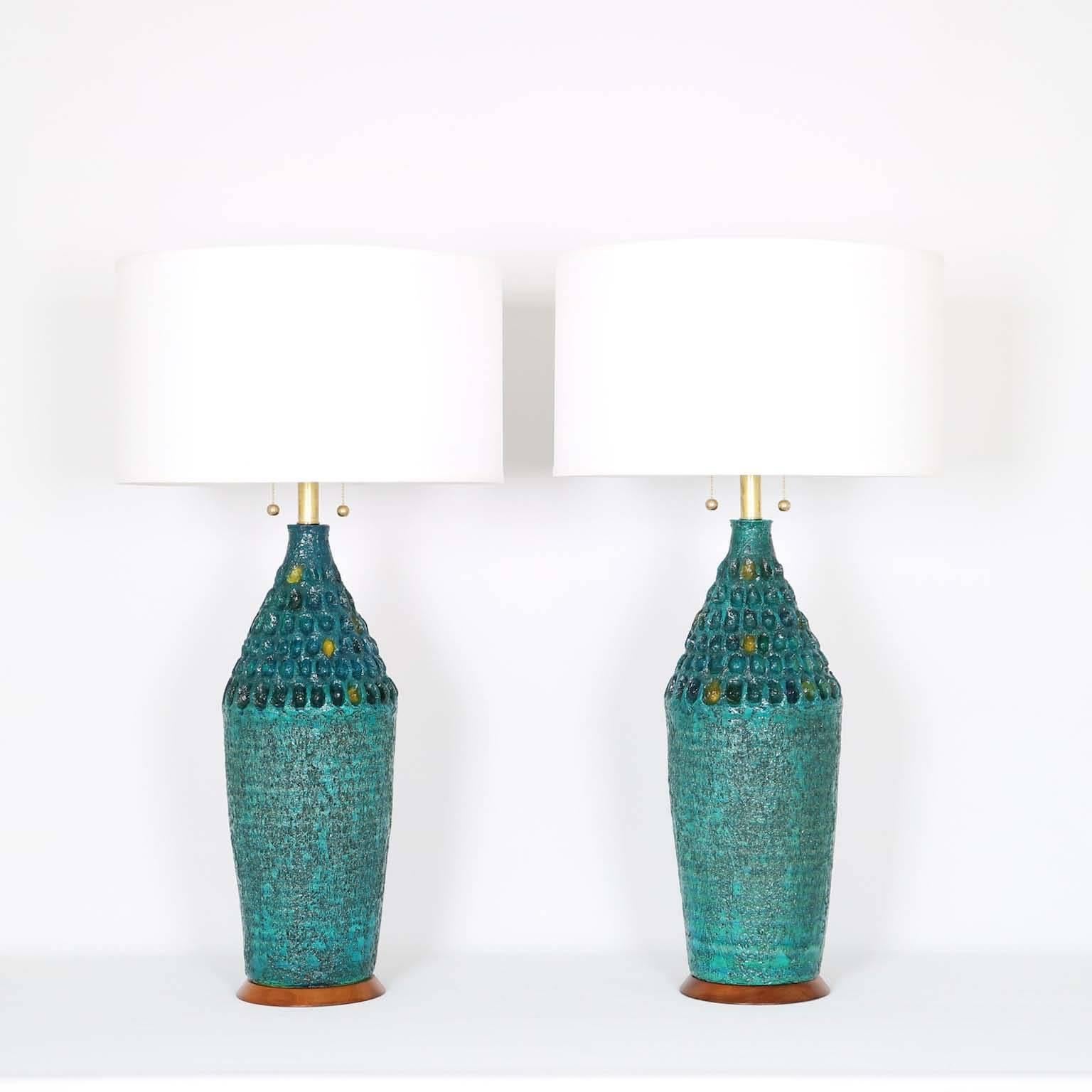 A pair of Brutalist style table lamps, produced by Quartite Creative Corp. and dated 1965, textured ceramic turquoise bodies, glazed in gorgeous tones of blues, greens and touches of yellow. The noted height is to the finial. Fully restored with all