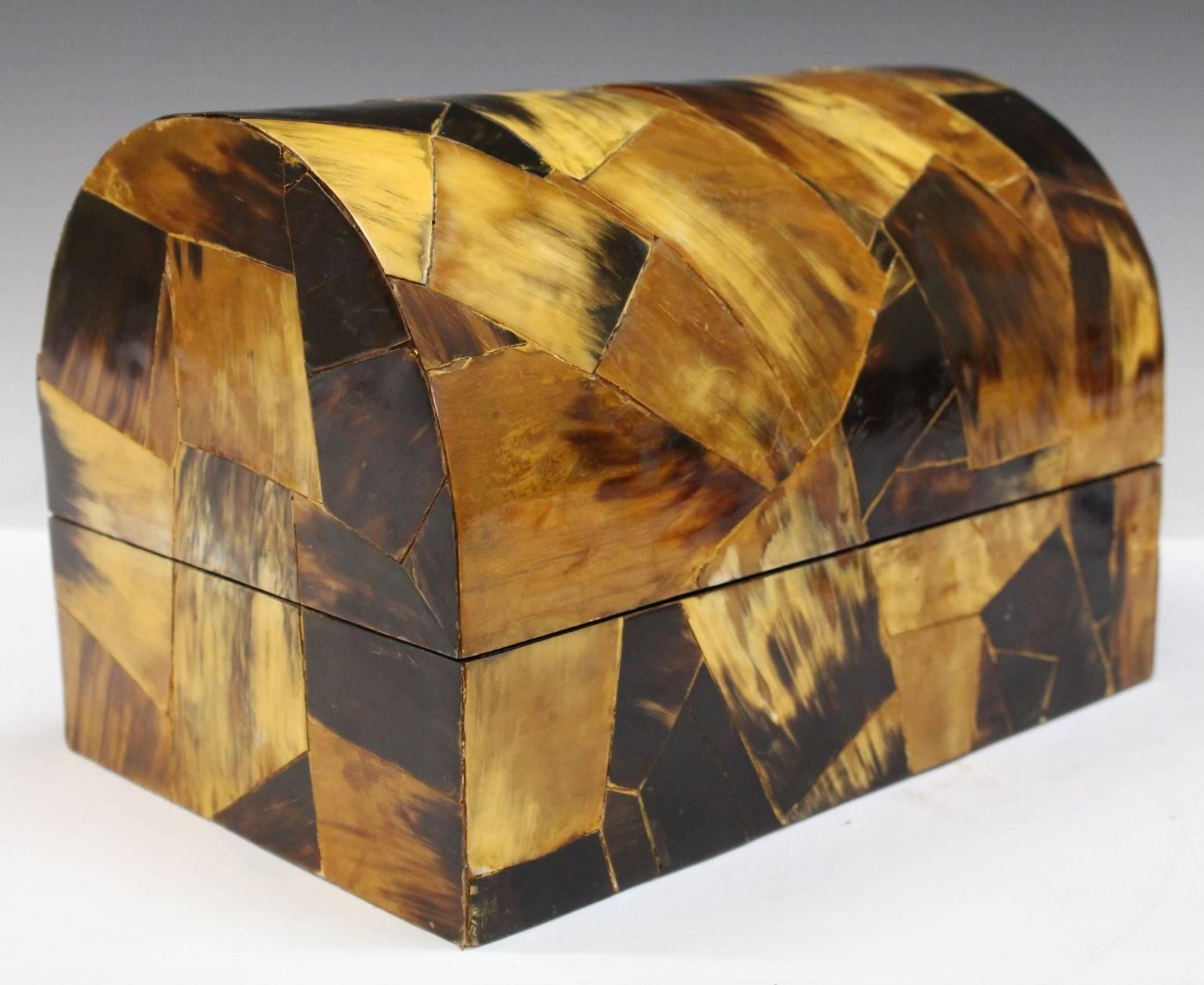 A vintage decorative box with hinged dome top, produced circa 1970s, entirely veneered in patchwork of multi-toned Horn. Overall good condition, consistent with age and use, including some wear to the interior.

9490