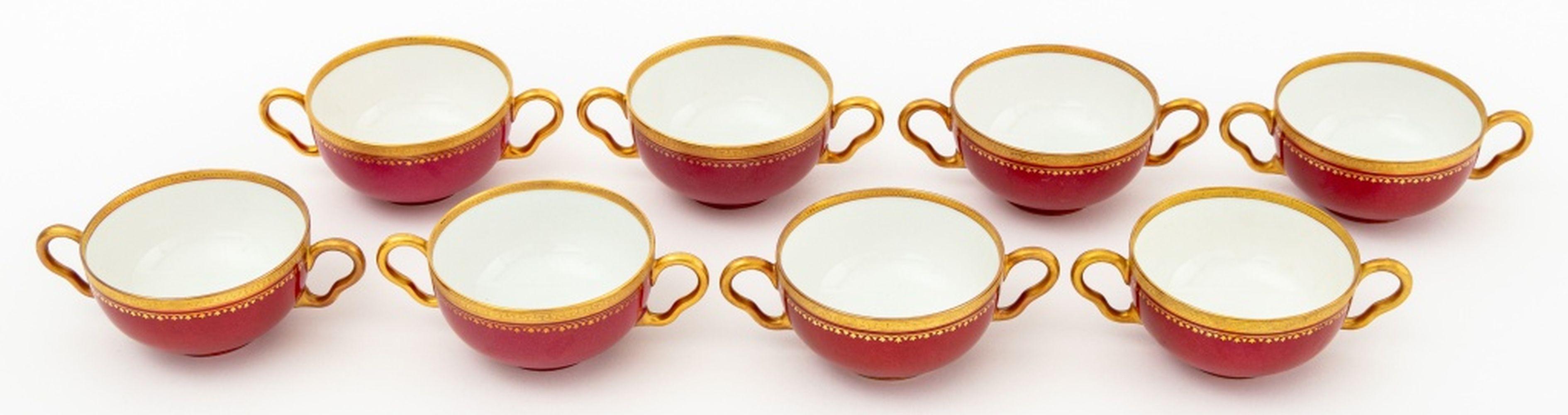 Set of 16 Richard Briggs for Limoges Painted Porcelain Table Articles, with red border and gilt greek key trim, comprising: (8) eight double-handled cream soup bowls and (8) eight matching saucers, marked 