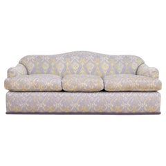 Sofá tapizado con tela estampada en tonos verde y morado de J. Robert Scott