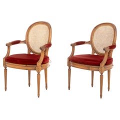 Ein Paar Sessel im Louis-XVI-Stil aus Walnussholz mit Rohrgeflecht und roten Samtpolstern