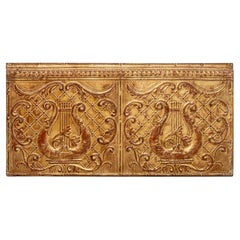 Pannello con motivo musicale in metallo dorato a tema architettonico