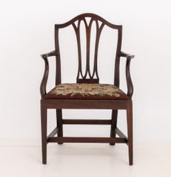 Sillón de caoba de estilo Jorge III con asiento abatible decorado con bordado floral