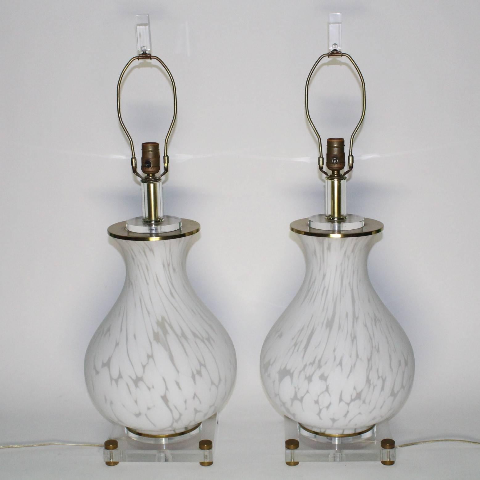 A pair of Italian table lamps by Mazzega, manufactured circa 1960s, each baluster form in mottled white Murano glass, mounted on Lucite bases with brass feet; Lucite finials included. Excellent original vintage condition.

10745