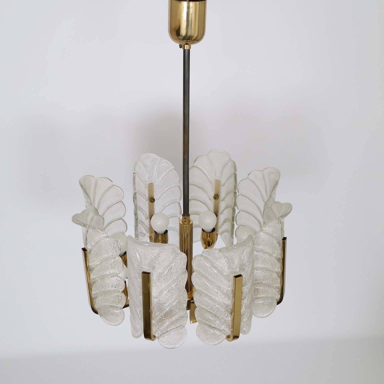 A chandelier by Carl Fagerlund for Orrefors of Sweden, elegant quality brass frame with eight-glass leaves as shades (fixed to frame by screws), with gloss and textured external finishes. The shade interiors have a layer of sparkling tiny shards of