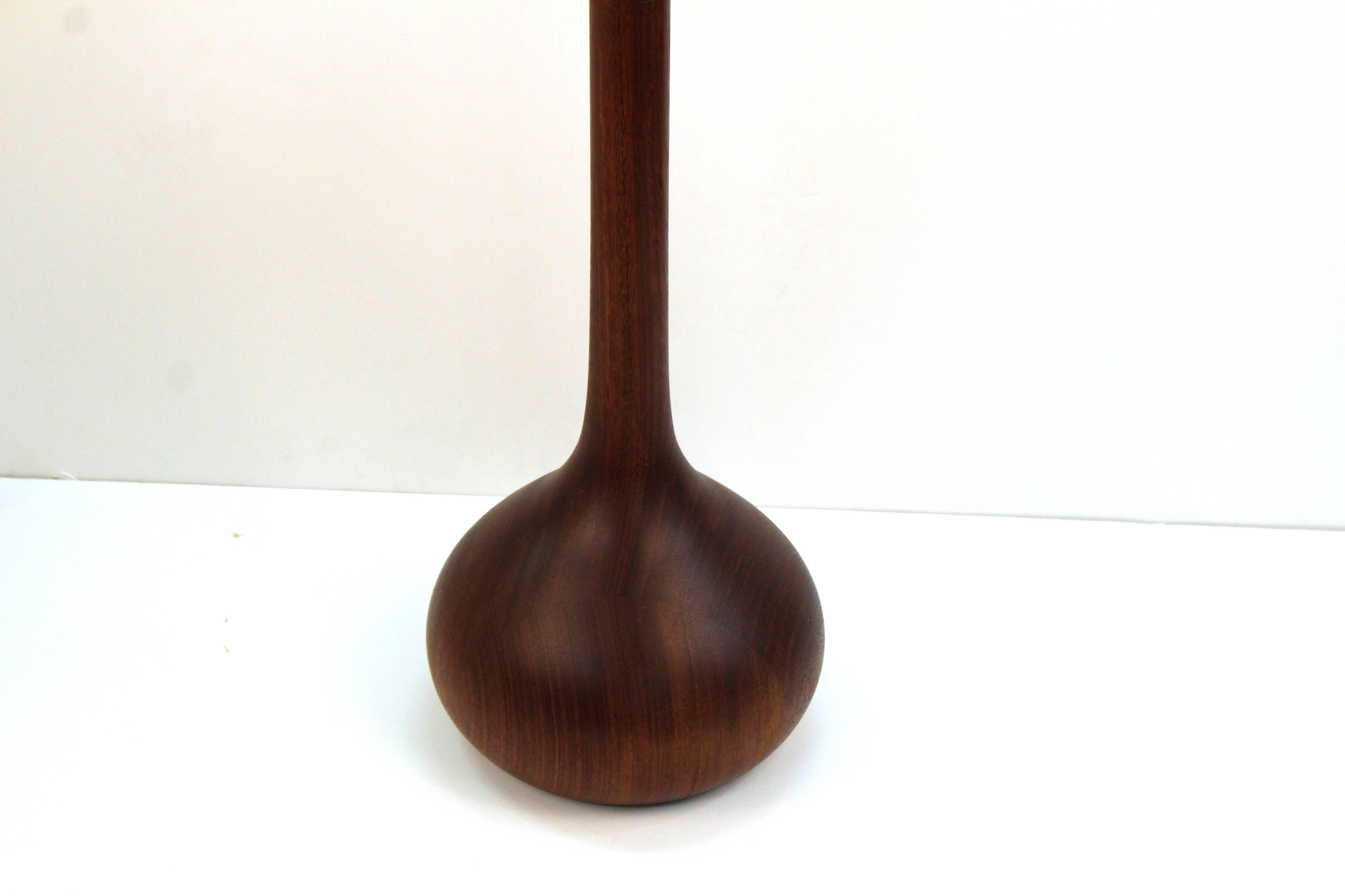 A vintage floor lamp produced in dark teak in a Classic 1960s style with an onion bulb base. 110369
 