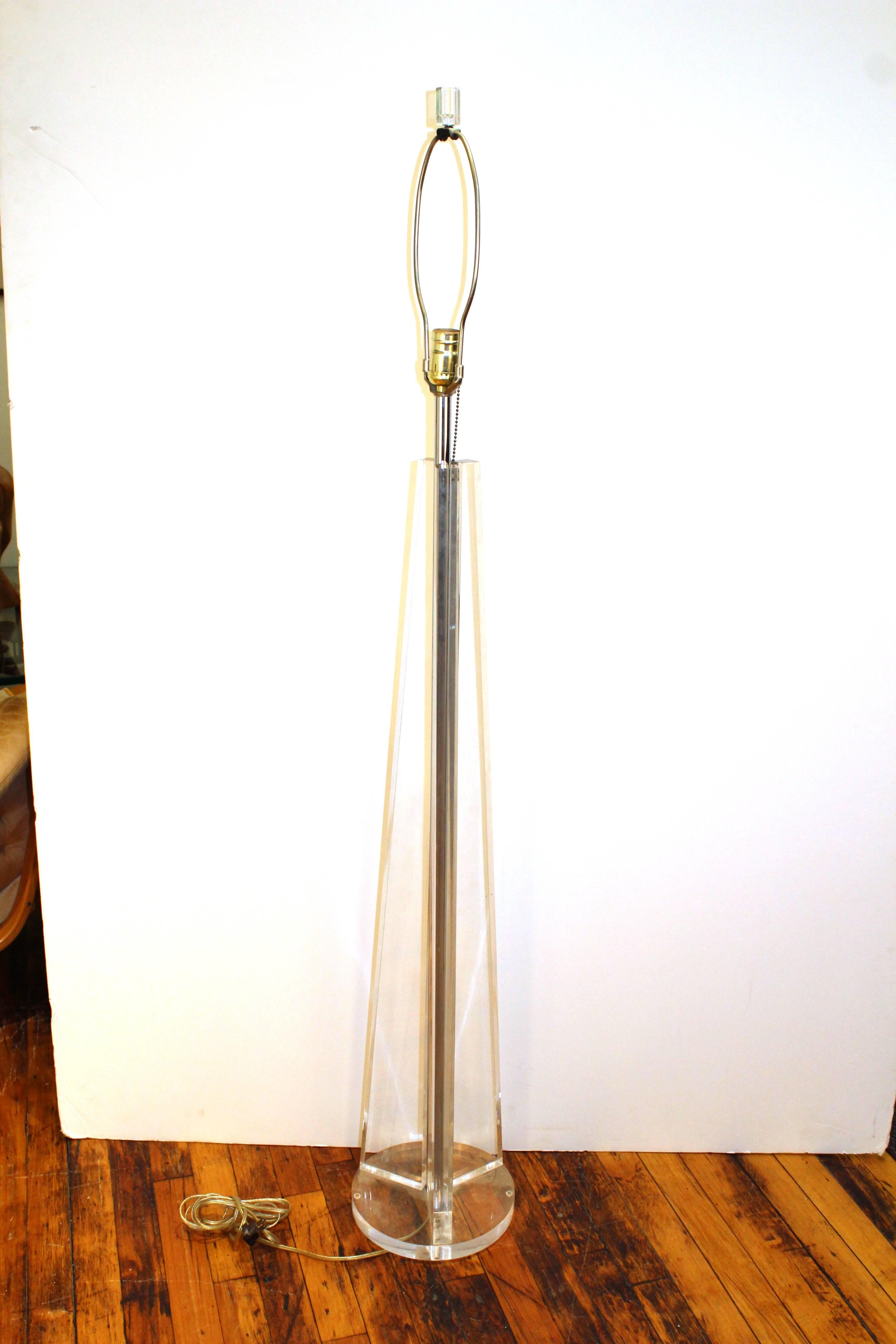 A Lucite floor lamp with three panels in a pyramidal position on a Lucite base.-110381.