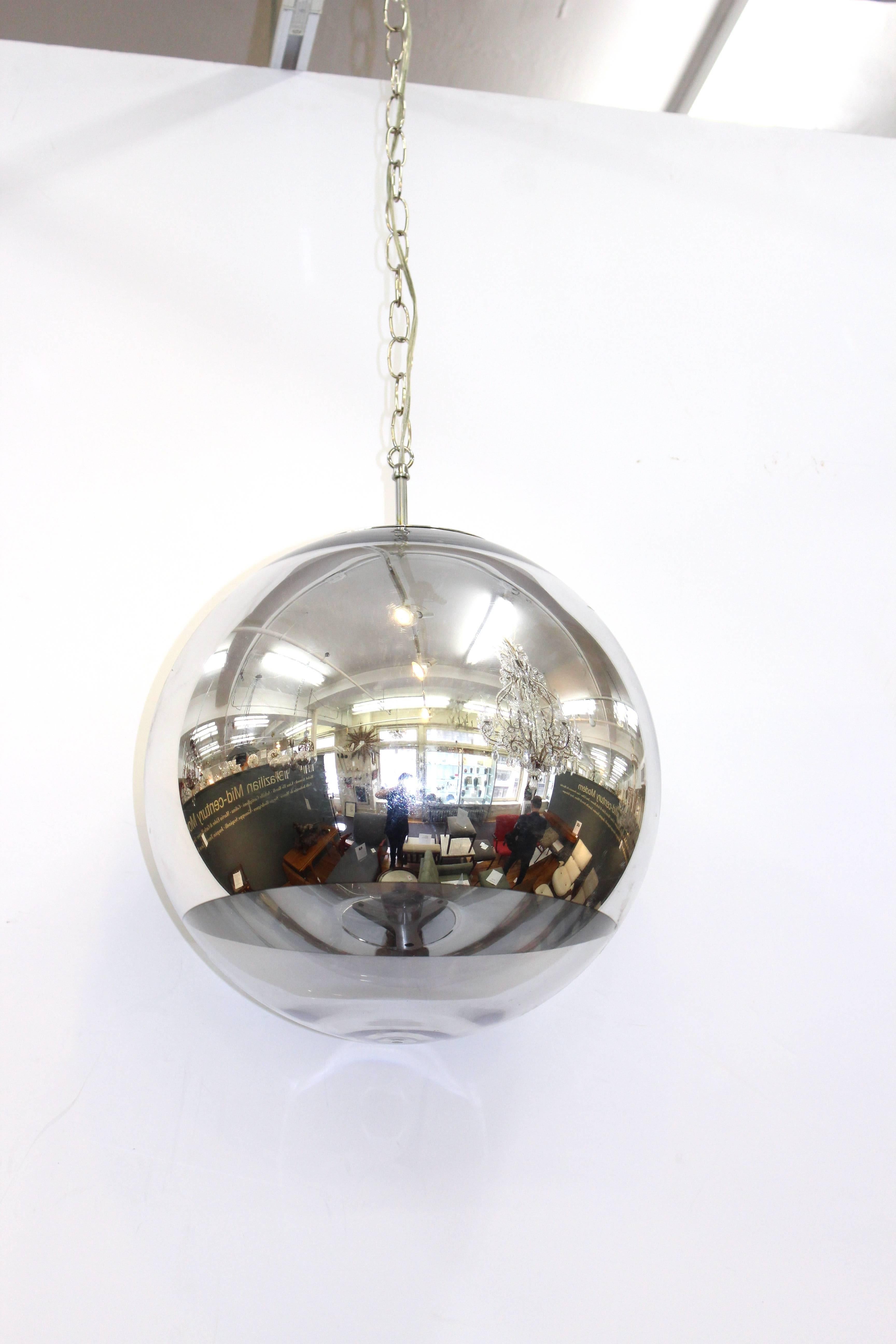 A stunning example of sleek Mid-Century design, this spherical pendant features a chrome shell with clear glass towards the bottom.

110491.