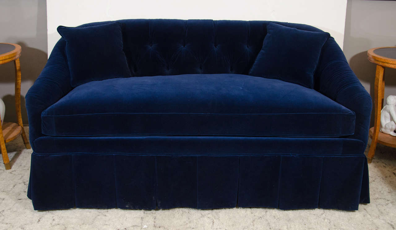 A button tufted velvet settee in midnight blue. Good condition, wear consistent with age and use.