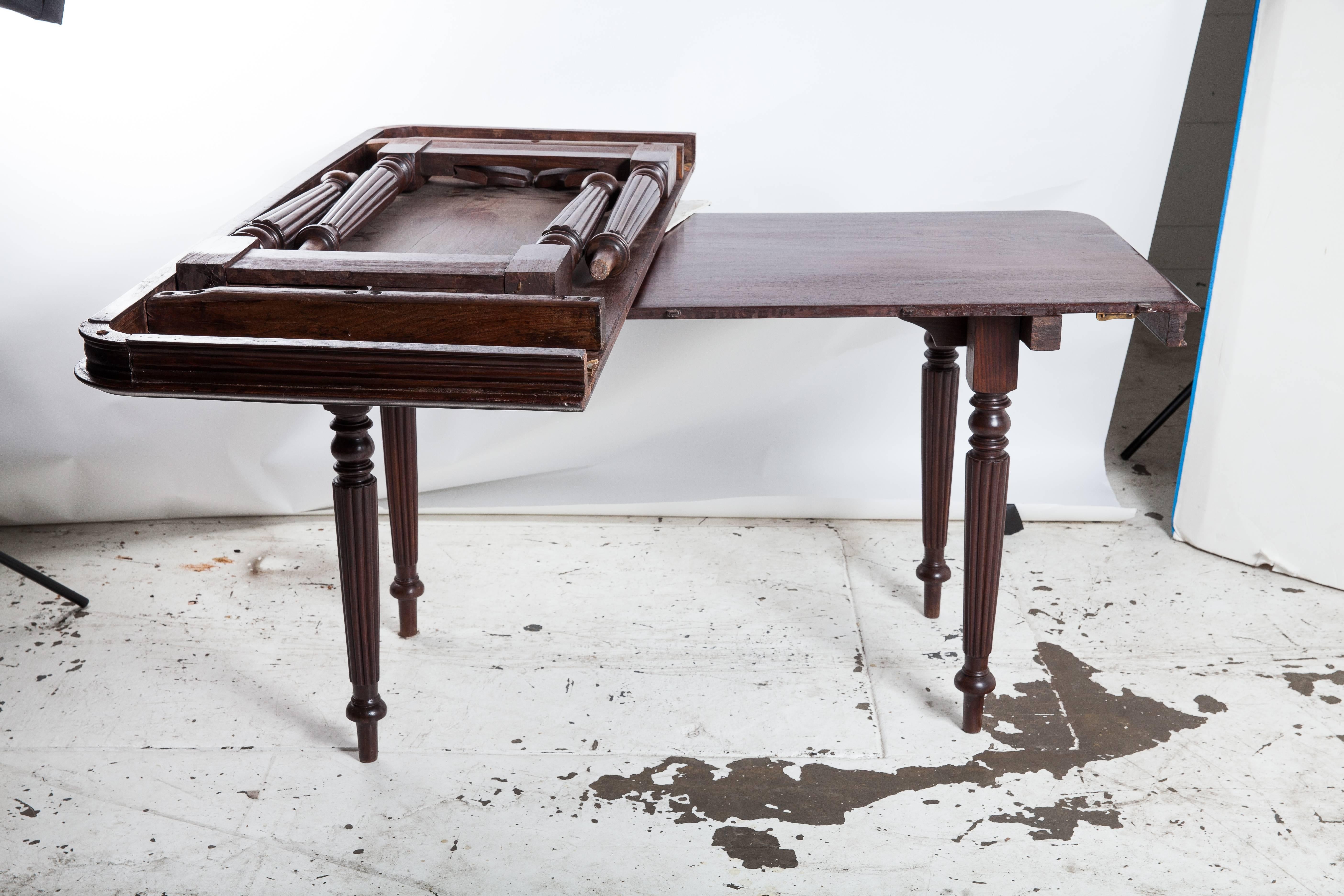 British Campaign solid rosewood table in two halves. Tables join together to form a single table or each half can be used as a console table. Turned, tapered legs. In true Campaign style, the table folds flat for easy transport.
 