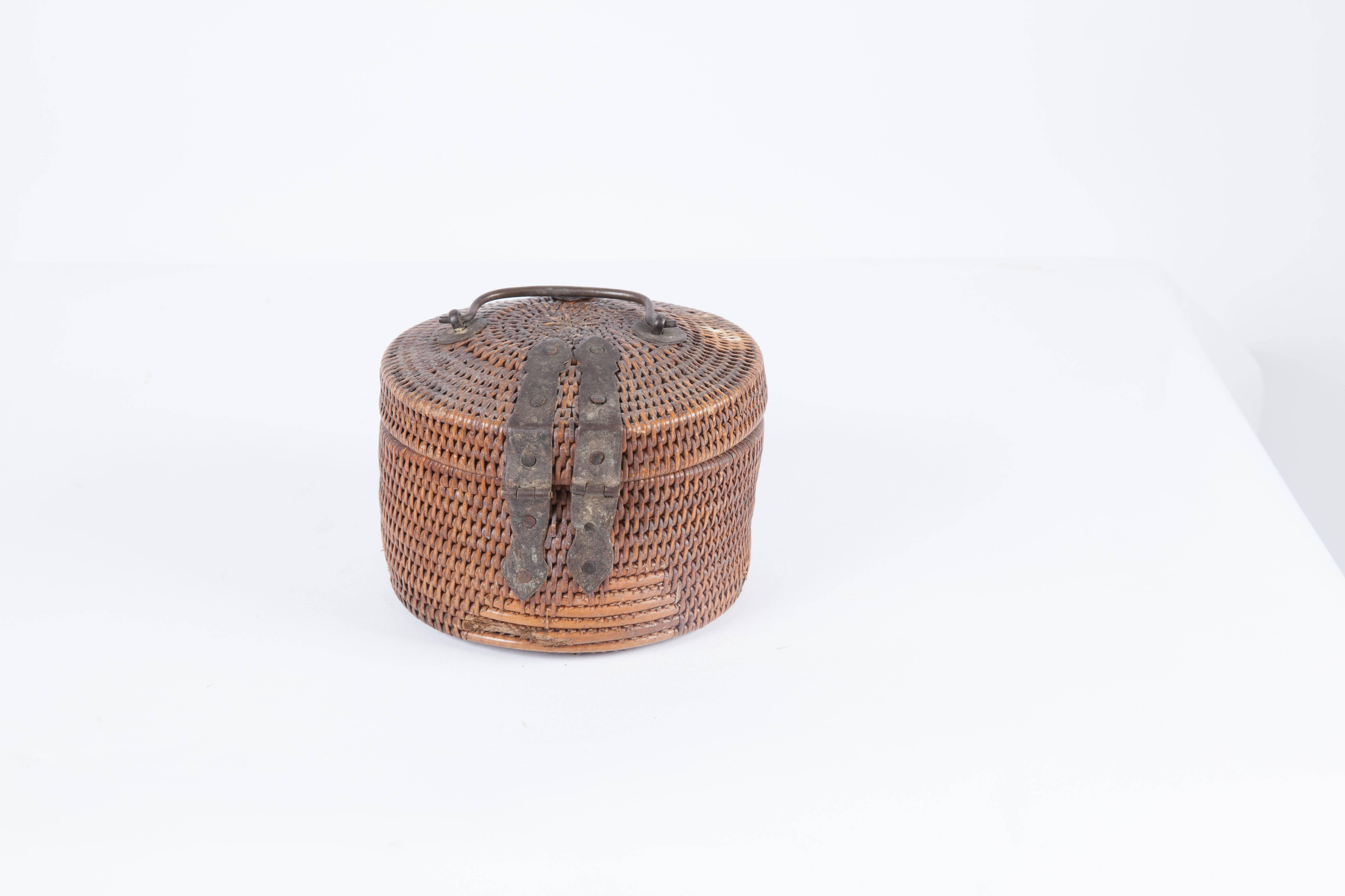 Rattan lidded basket with metal enclosure and handle.