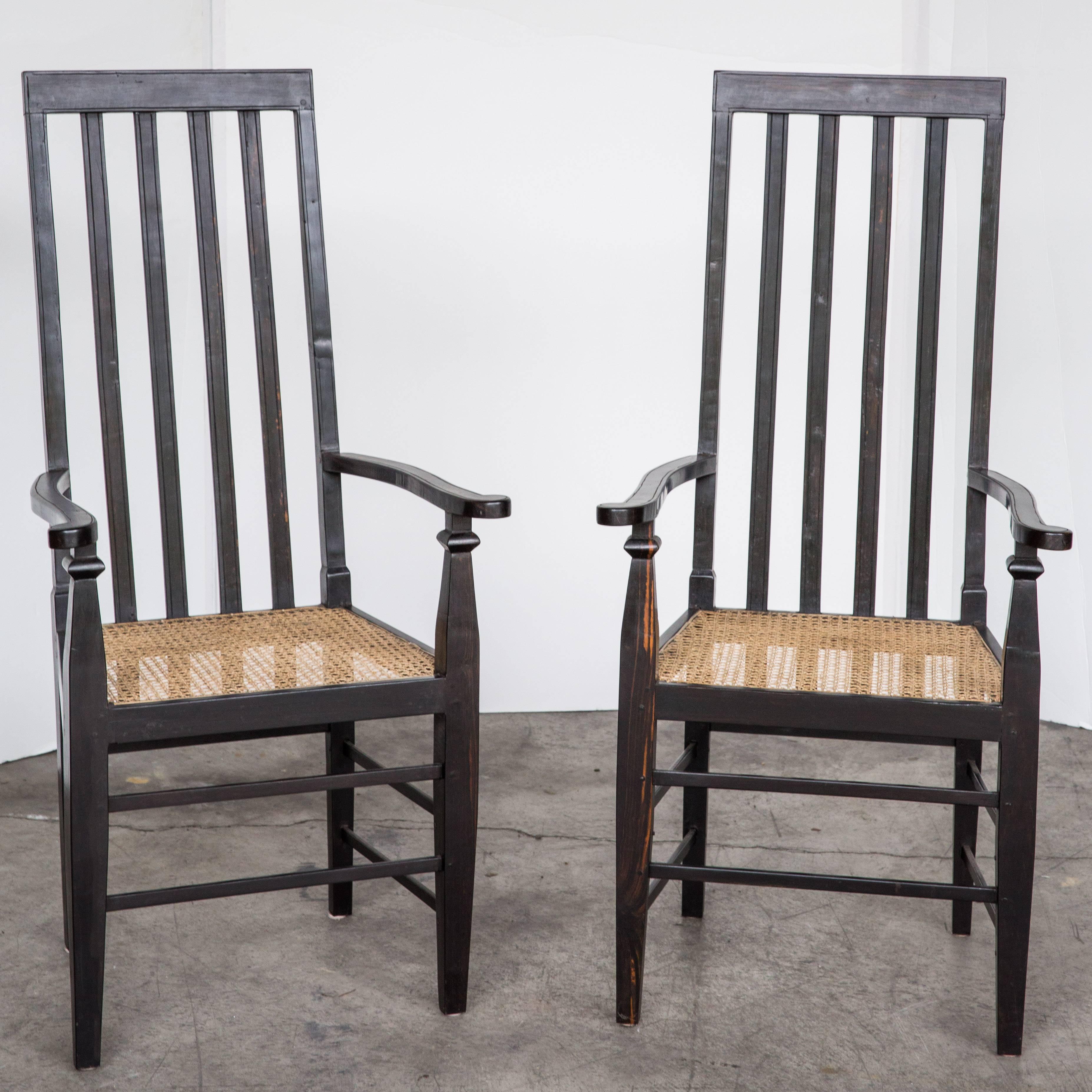 Made of solid ebony with a newly caned seat. The back of the chair is unusually high with a comfortable lean angle. Arms have slight curve with simple straight engraving along the edges. Caning is newly done.