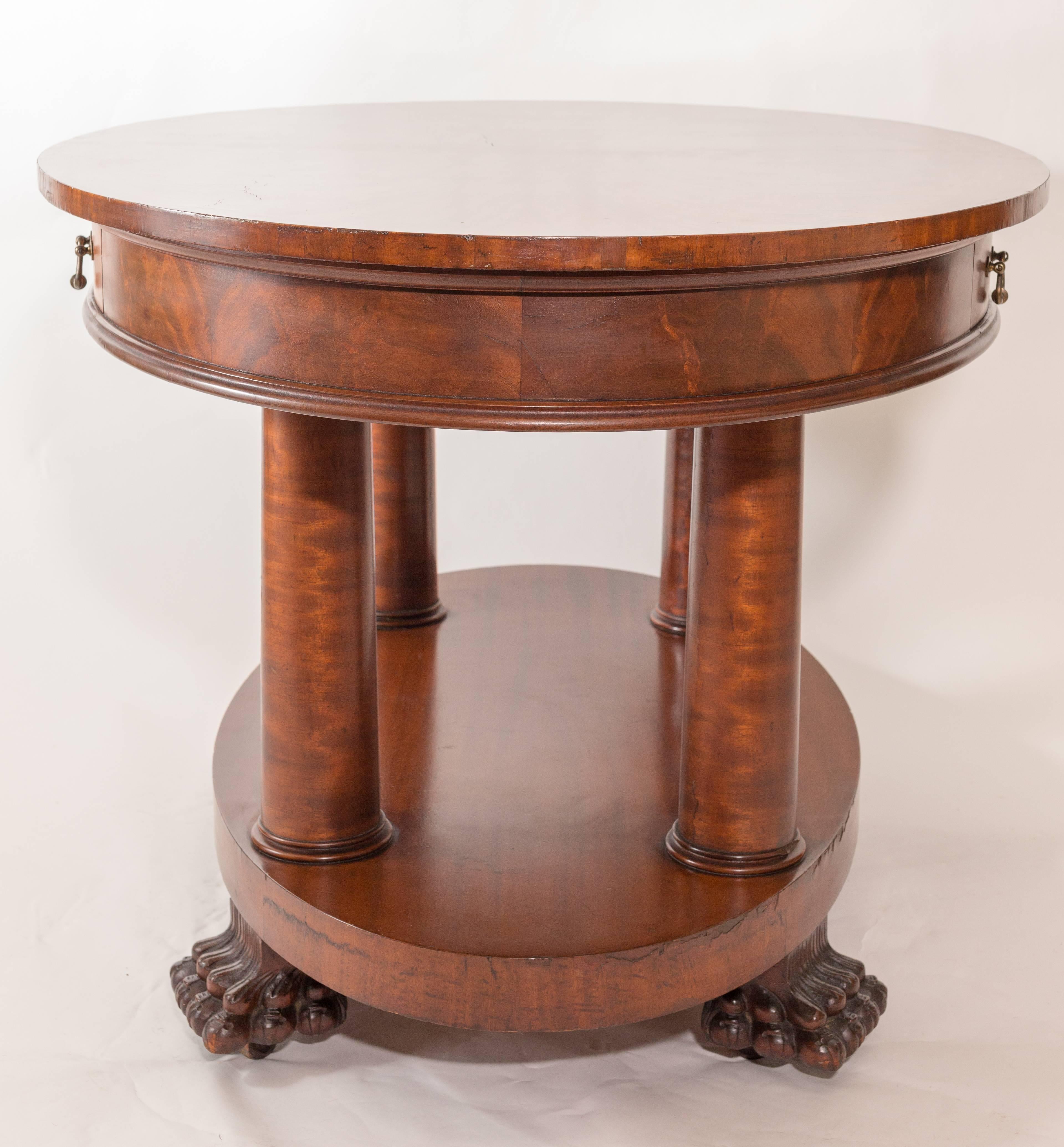 Beautiful Mahogany Empire table with claw feet and its original casters. Pillar legs. Brass hardware on drawers with dovetail detail inside.