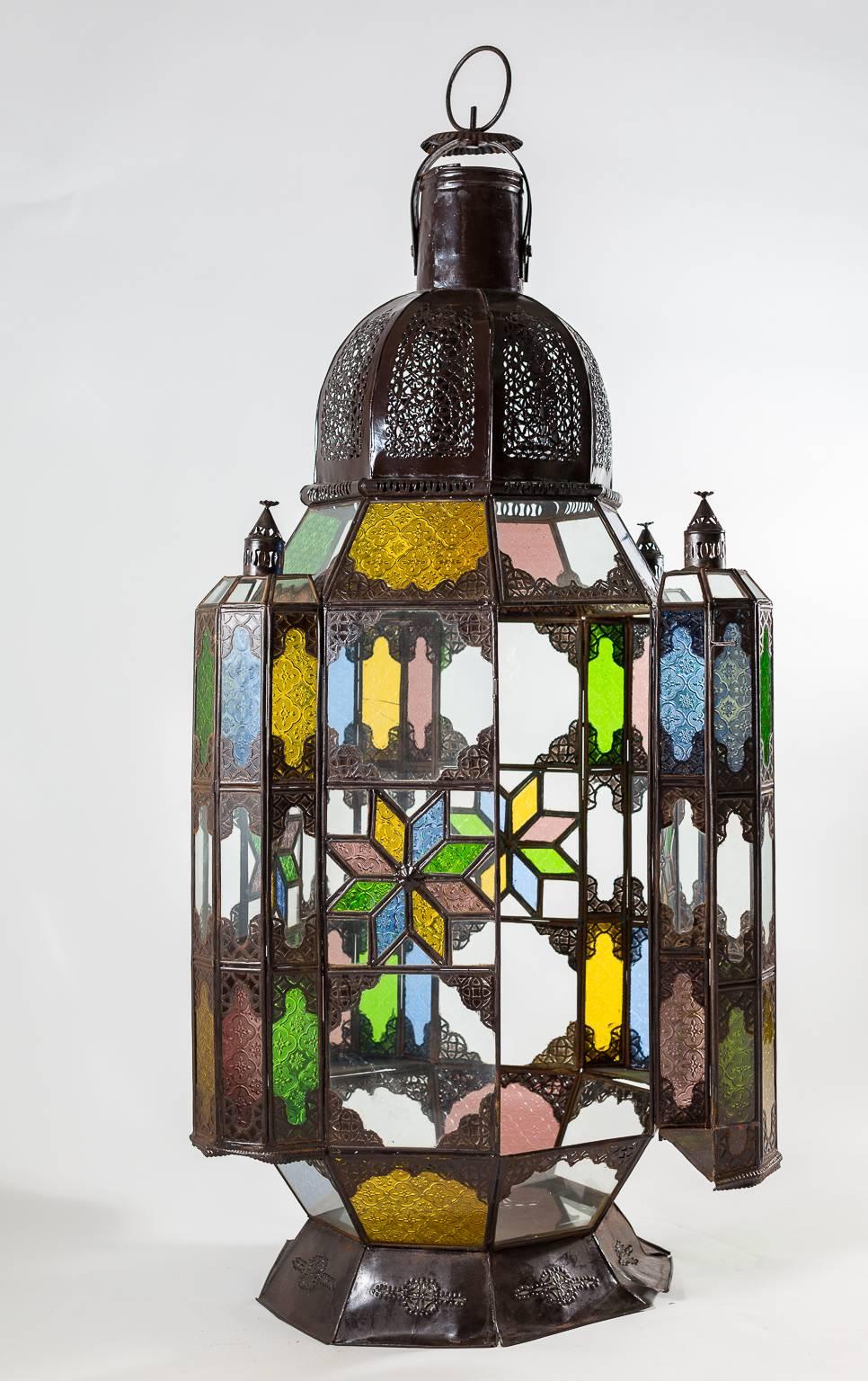 Lantern with corner compartments and glass colored planes.
Bronze toned filigree frame which can stand or hang.
May house candles or electric bulbs.
 