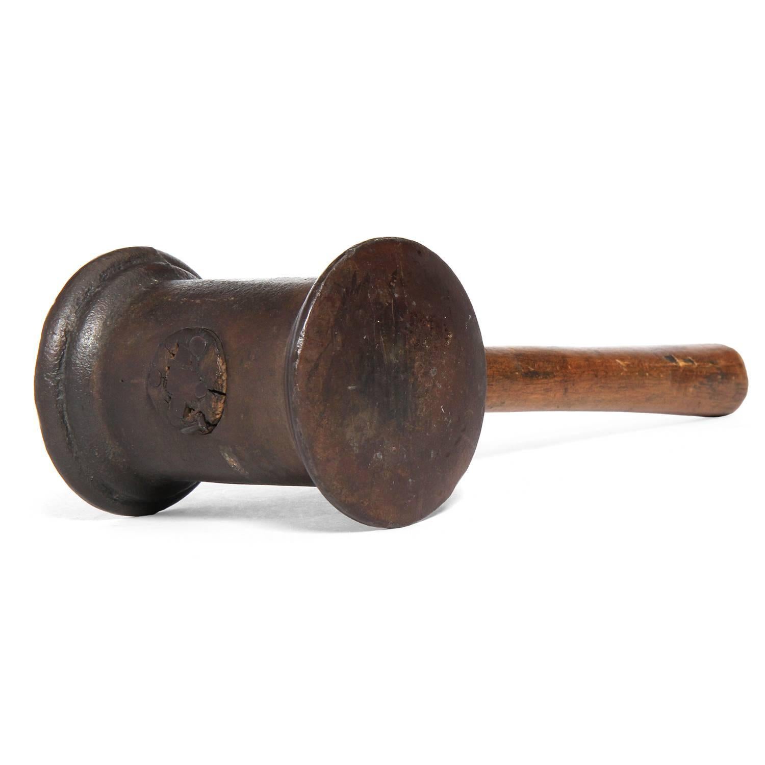 A fine and unusual hammer used to pulverize gold into leaf, having a warmly toned oak handle attached to patinated steel head.