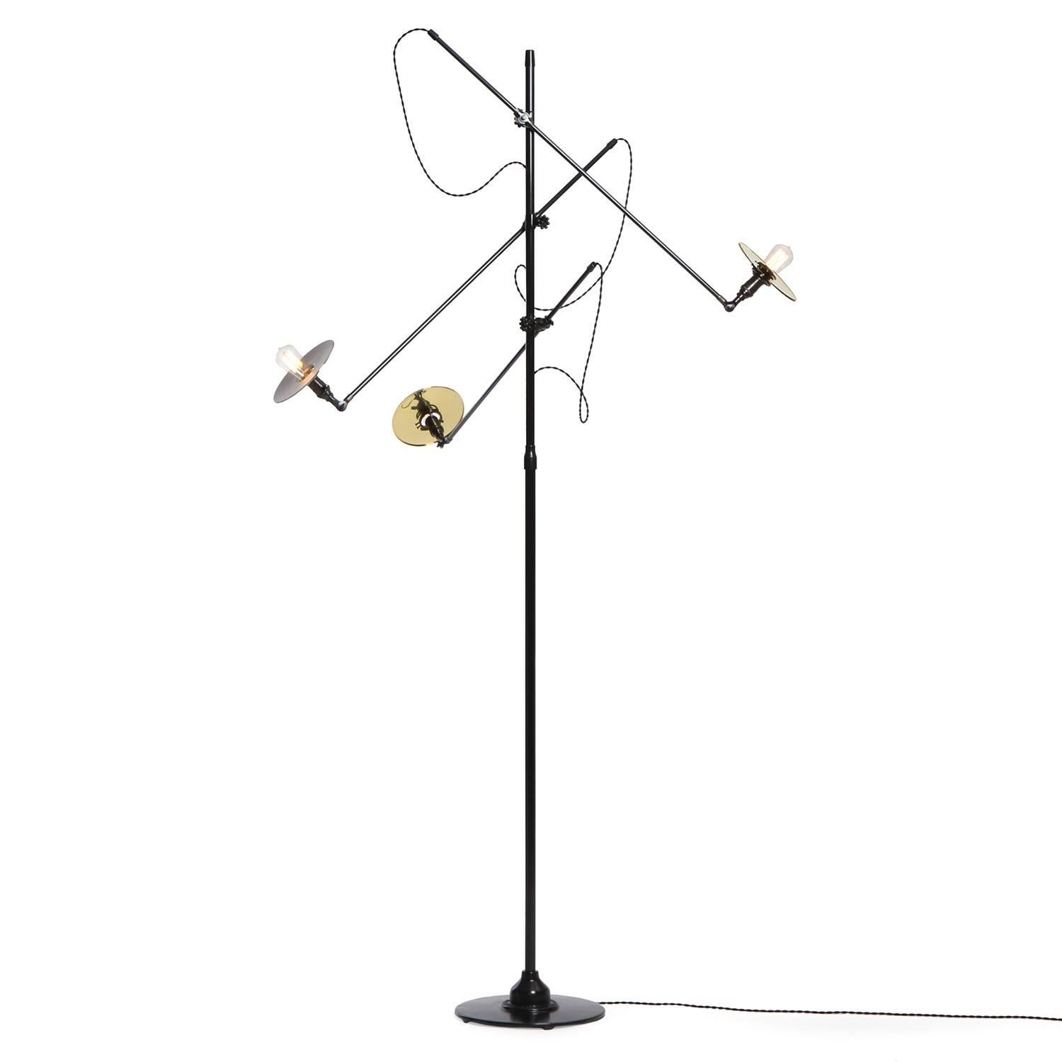 A 3-arm Industrial style floor lamp manufactured by O.C. White featuring impressively scaled and finely fabricated parts in patinated steel and polished brass. Lamp features three articulating arms that also can be adjusted vertically, rising from a