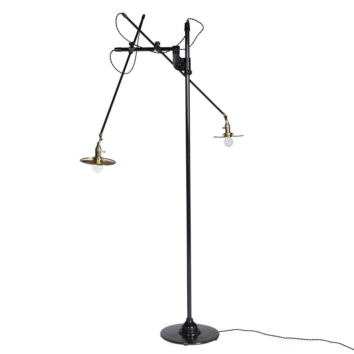 An impressively scaled and finely fabricated floor lamp in patinated steel and polished brass having two articulating arms off of an adjustable arm, having a stepped disc base.
