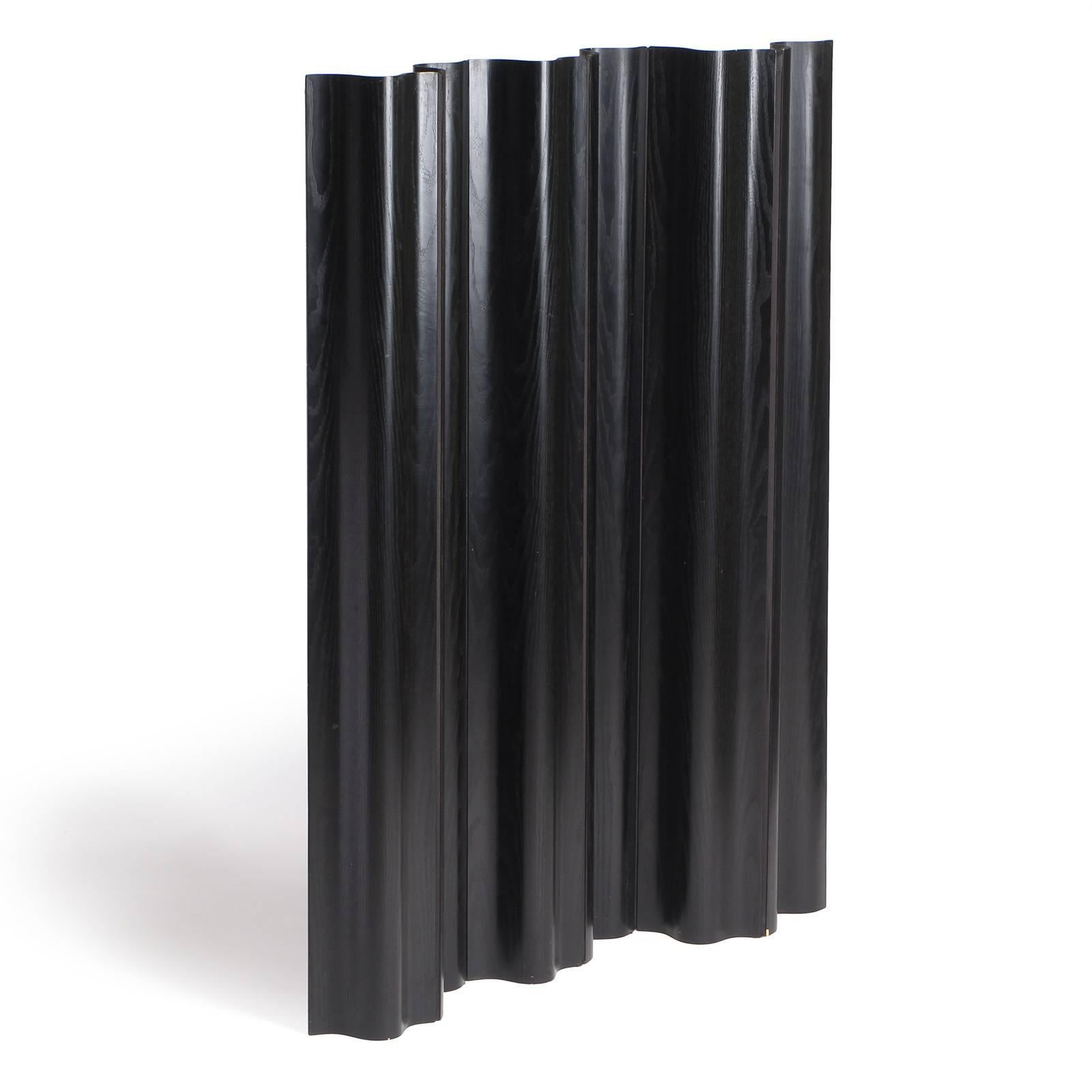An undulating and adjustable six panel molded plywood screen, black satined ash panels connected by fabric 