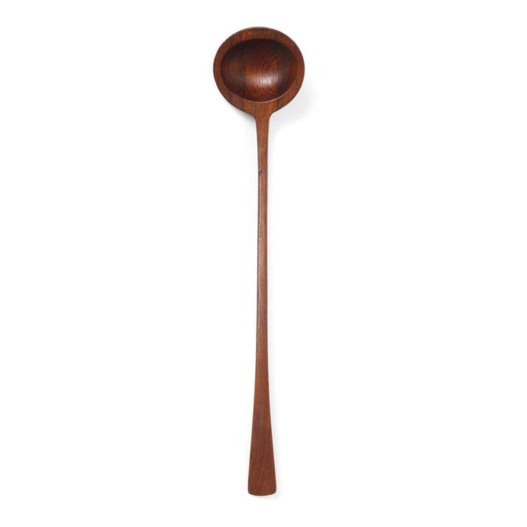 A pair of hand carved teak serving spoons with curved elongated handles.