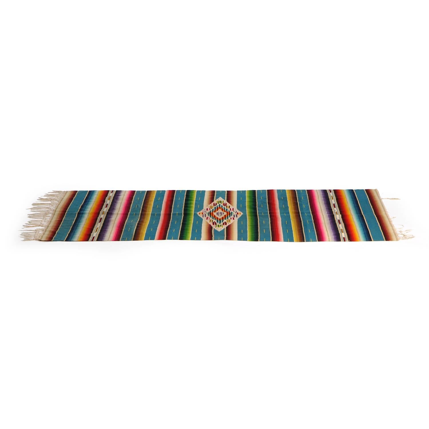 A finely crafted and vibrantly hued striped hand loomed wool serape from Saltillo, Mexico.