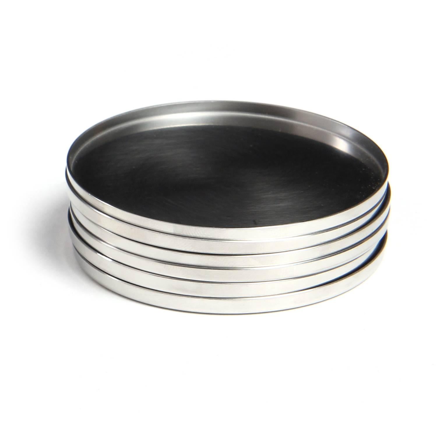A grouping of six spare and superb brushed stainless steel coasters from the 