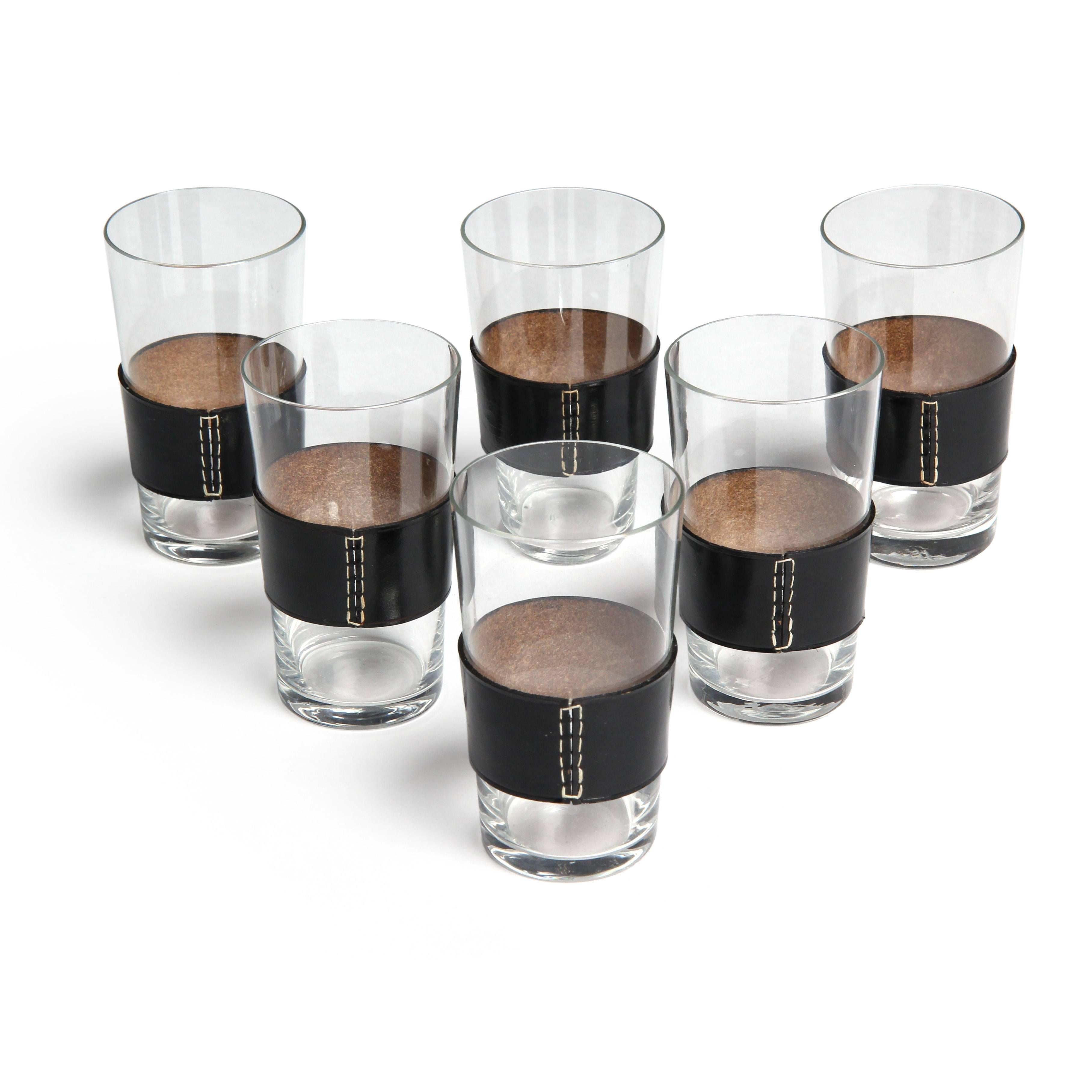 A refined glass pitcher and six (6) glasses, having hand-stitched black leather sleeves and integrated handle on the pitcher.