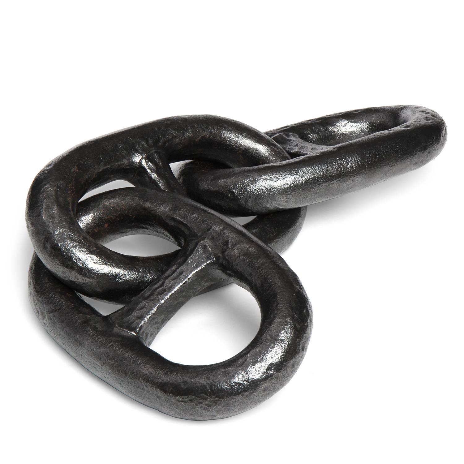 A group of three large connected patinated forged iron chain links.