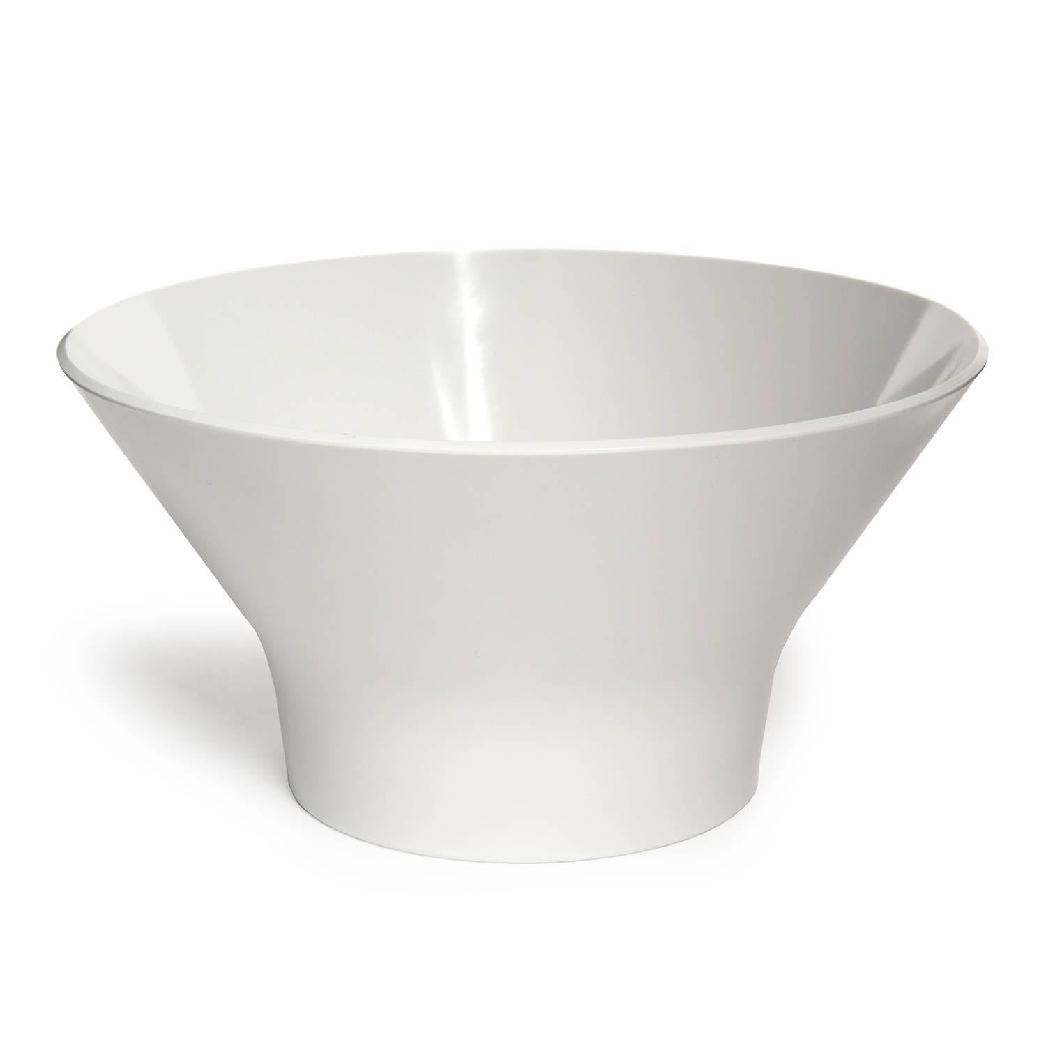 A sculptural and graphic round footed plastic serving bowl having an expressive flaring form.