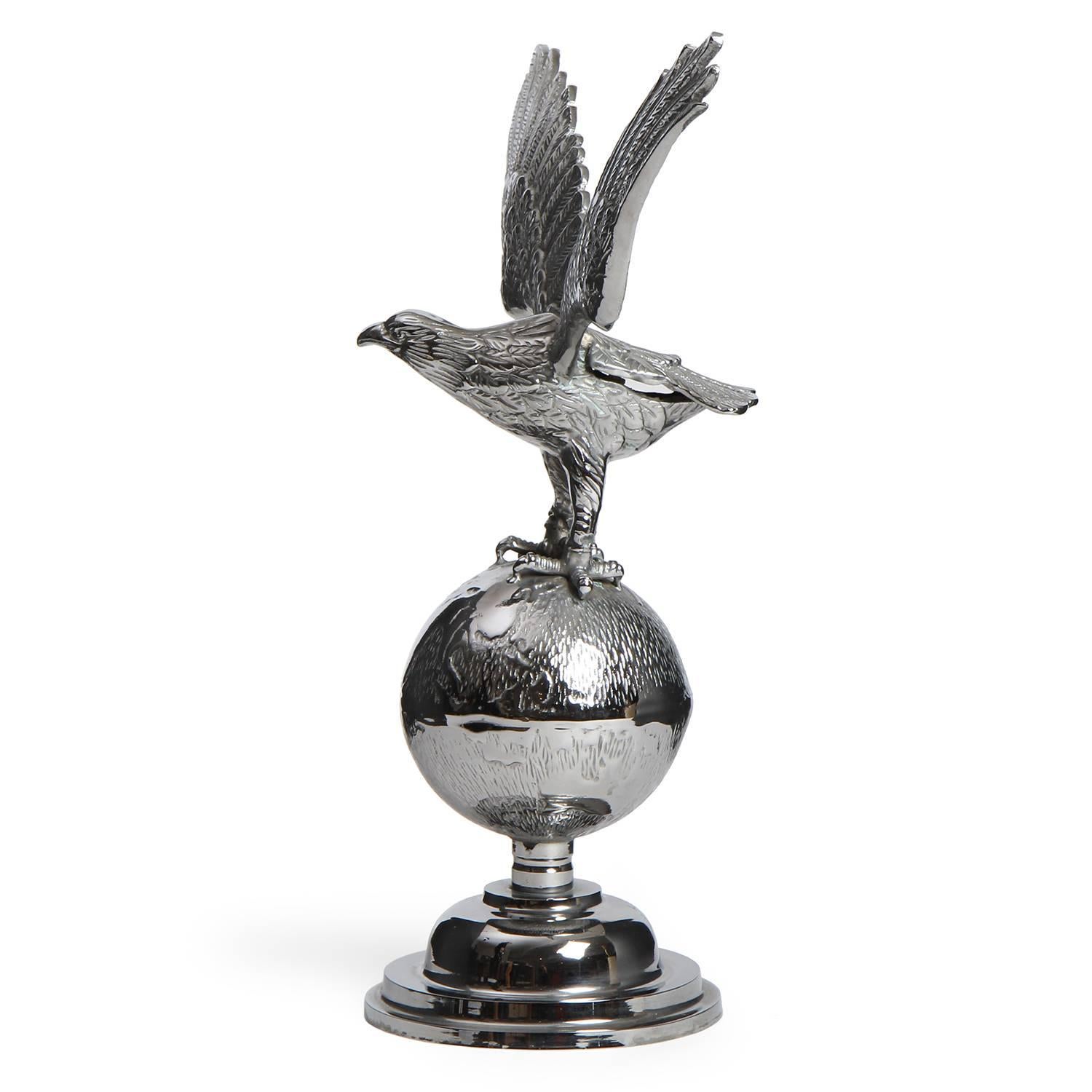 A finely detailed and naturalistically modeled eagle dramatically perched atop a globe mounted on a stepped base, the entire form rendered in chromed steel.
