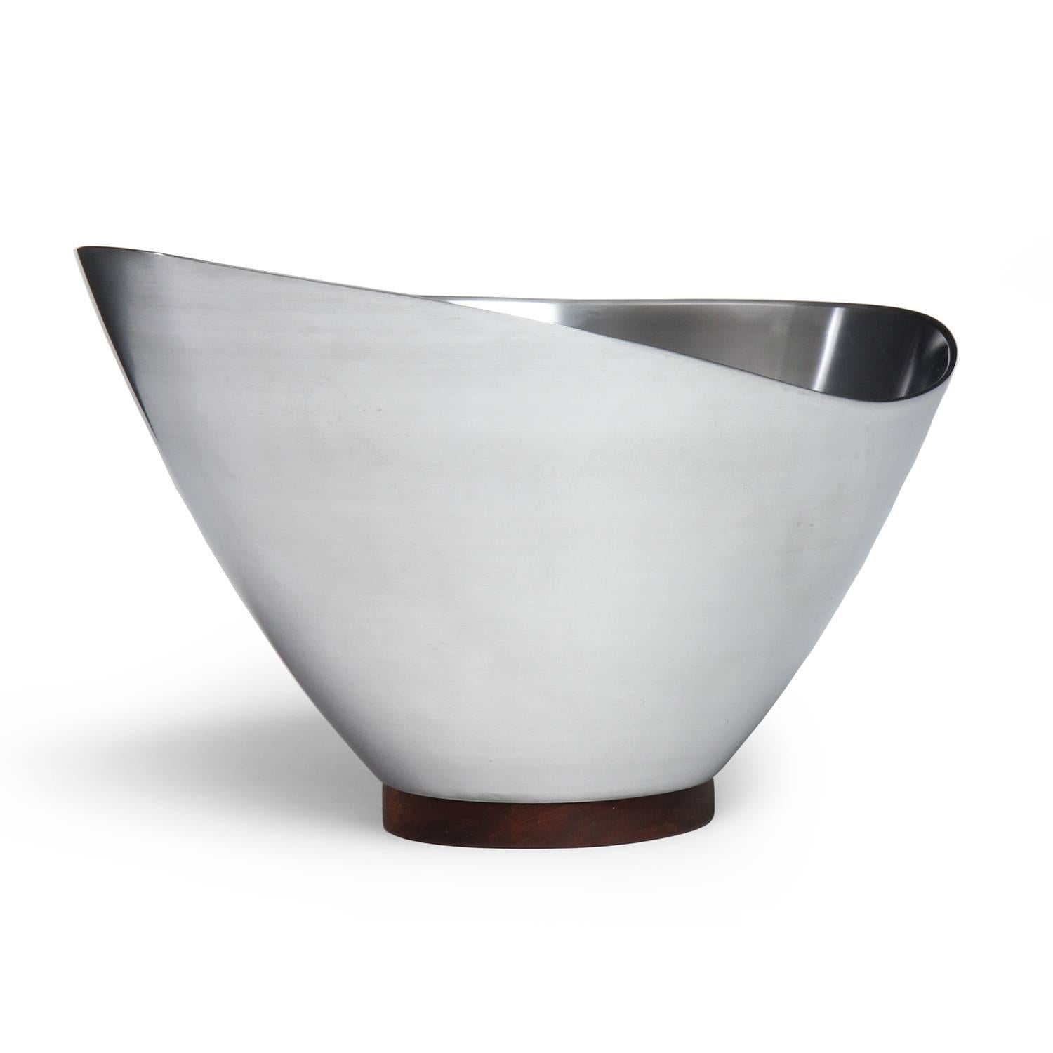 A well scaled and finely rendered spun steel bowl having an organic undulating edge and perched on a walnut foot.