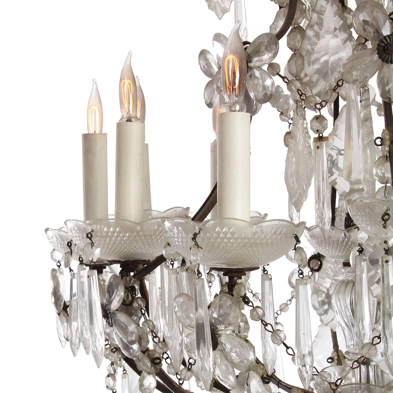 An elegant, well scaled and dramatic chandelier having an expressive scrolling armature embellished with fine cut crystal elements.