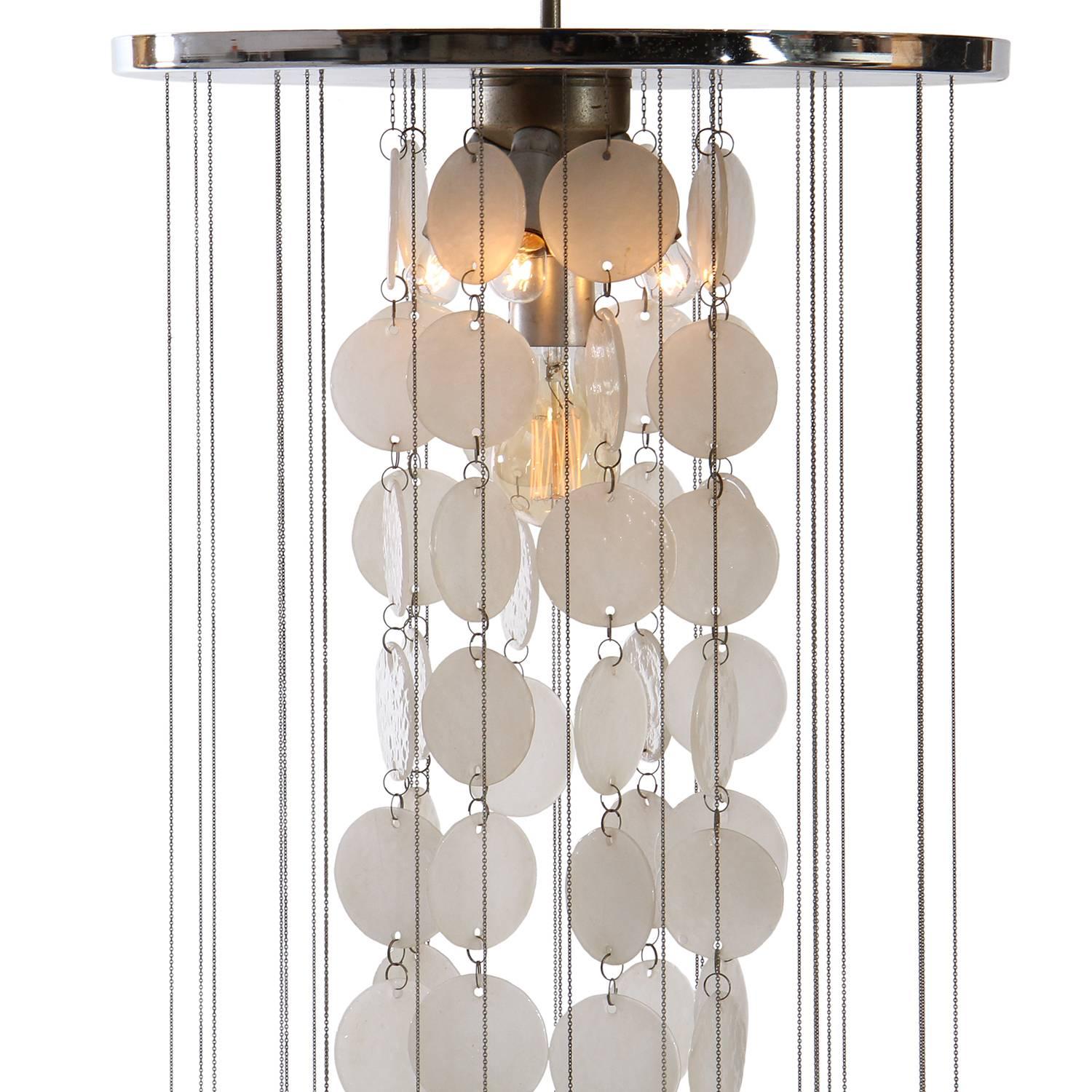 An expressive and well-scaled chandelier having rows of floating translucent Murano milk glass discs cascading down from a round chromed steel ceiling plate.