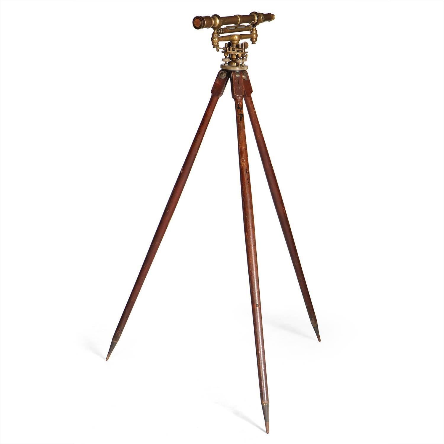 An impeccably machined surveyor's transit made of warmly patinated brass and mounted on its original walnut tripod stand.