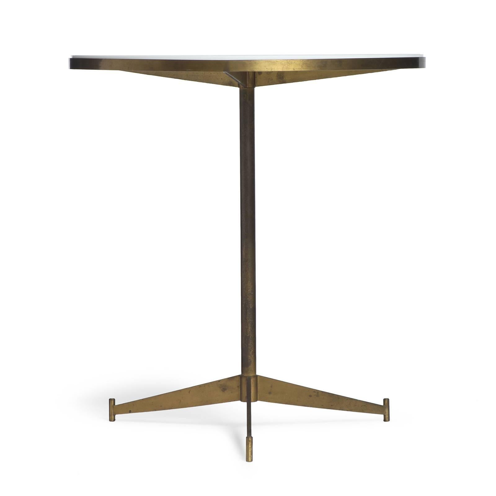 A fine brass side table having an inset opaque white glass top, pedestal with tripod base.