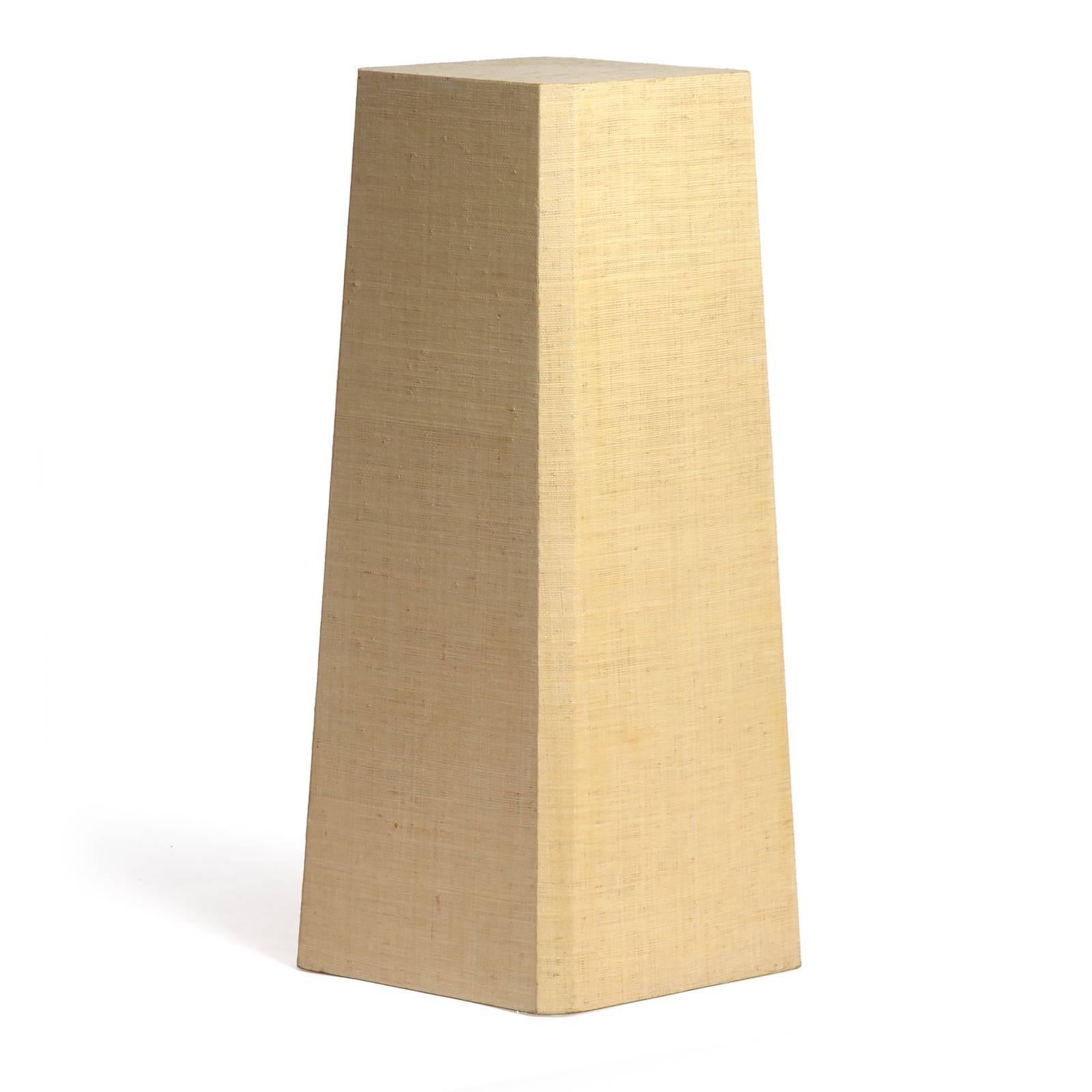 A well scaled raffia-wrapped pedestal having a subtly tapered form and eased corners. 