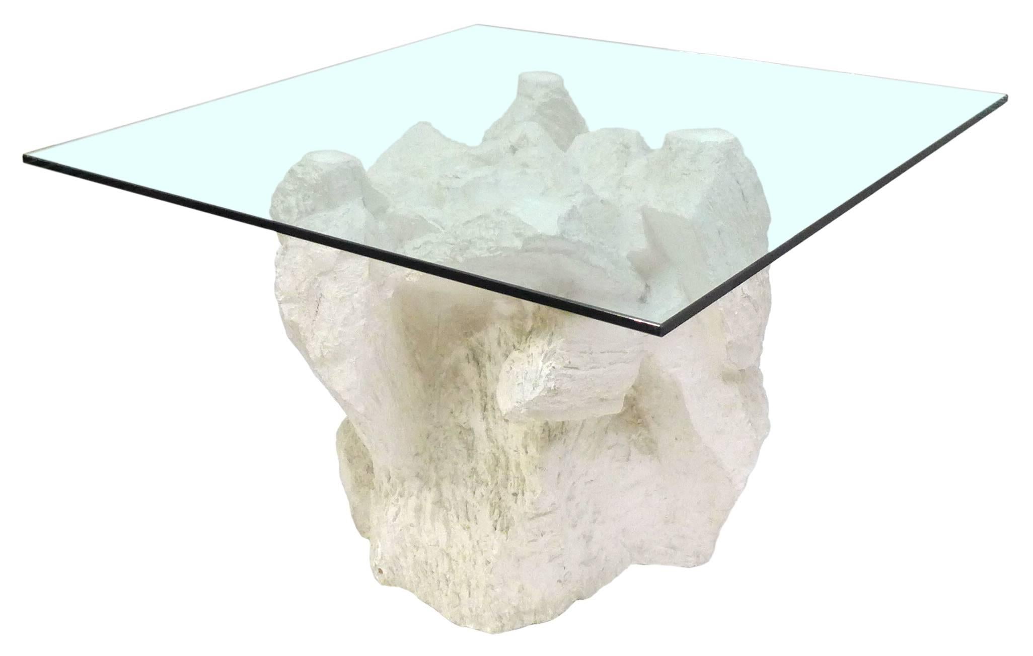 A wonderful and unusual hollow-cast plaster, glass-top side table by Sirmos. An extraordinary and eye-catching item, the base cast as a lifelike, natural rock formation in an out-of-context material taking an organic element to a more surreal place.
