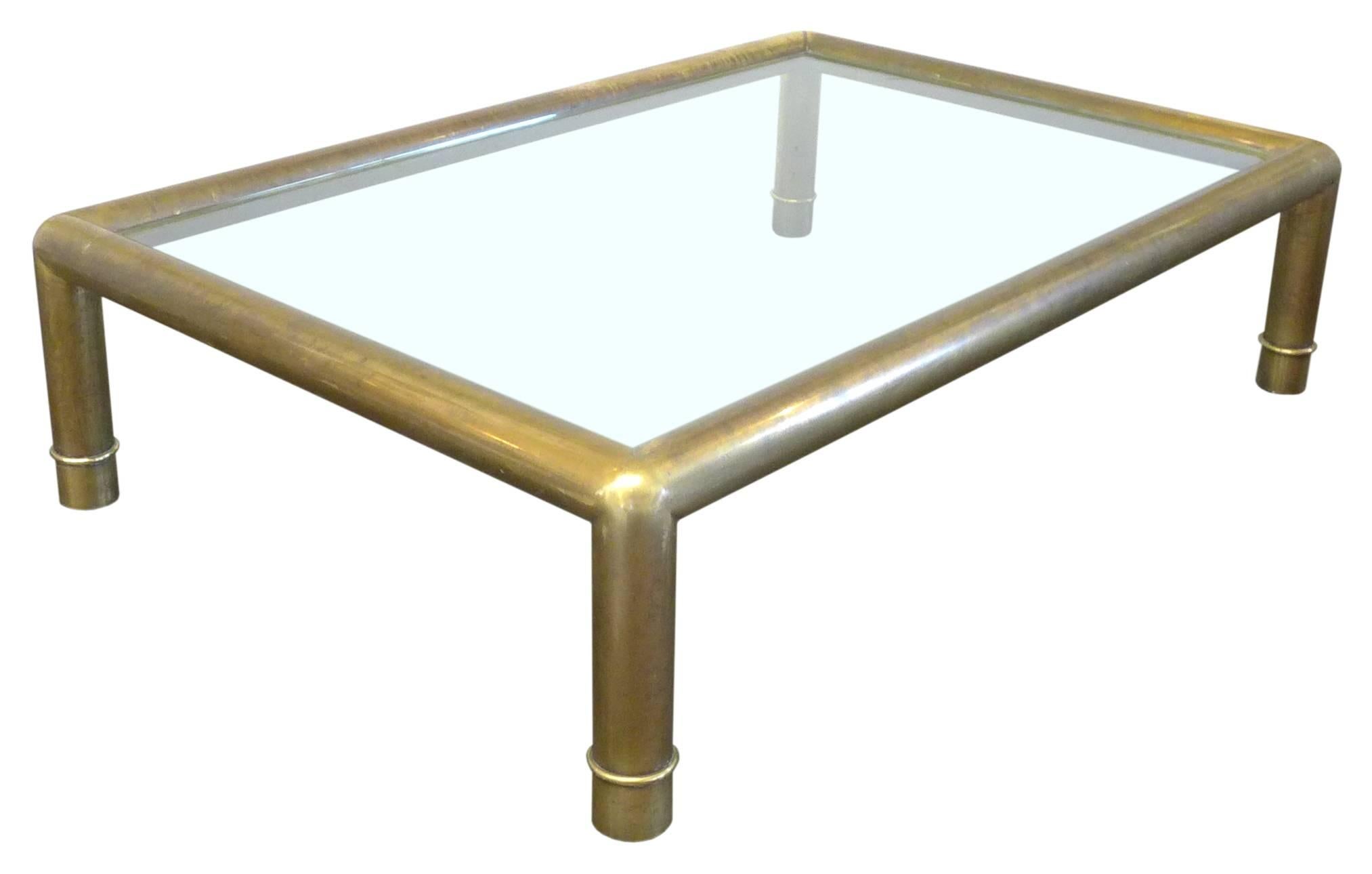 A wonderful, large, rectangular brass and glass coffee table by Mastercraft. A simple, elegant frame of thick-gauge tubular brass with subtle ring-detail at each leg. Great impressive scale and much desired patina throughout. An outstanding example