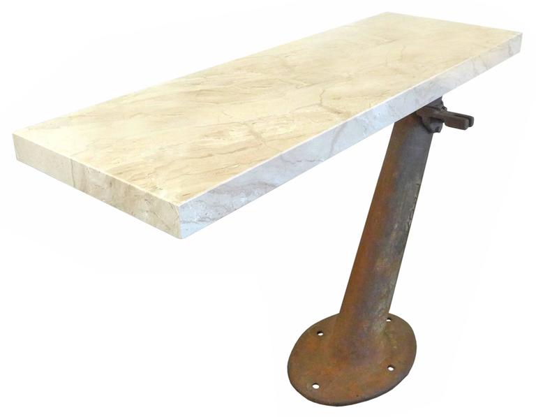 An incredible and unusual cantilevered console table of travertine and cast iron. Appendage-adorned and monogrammed 