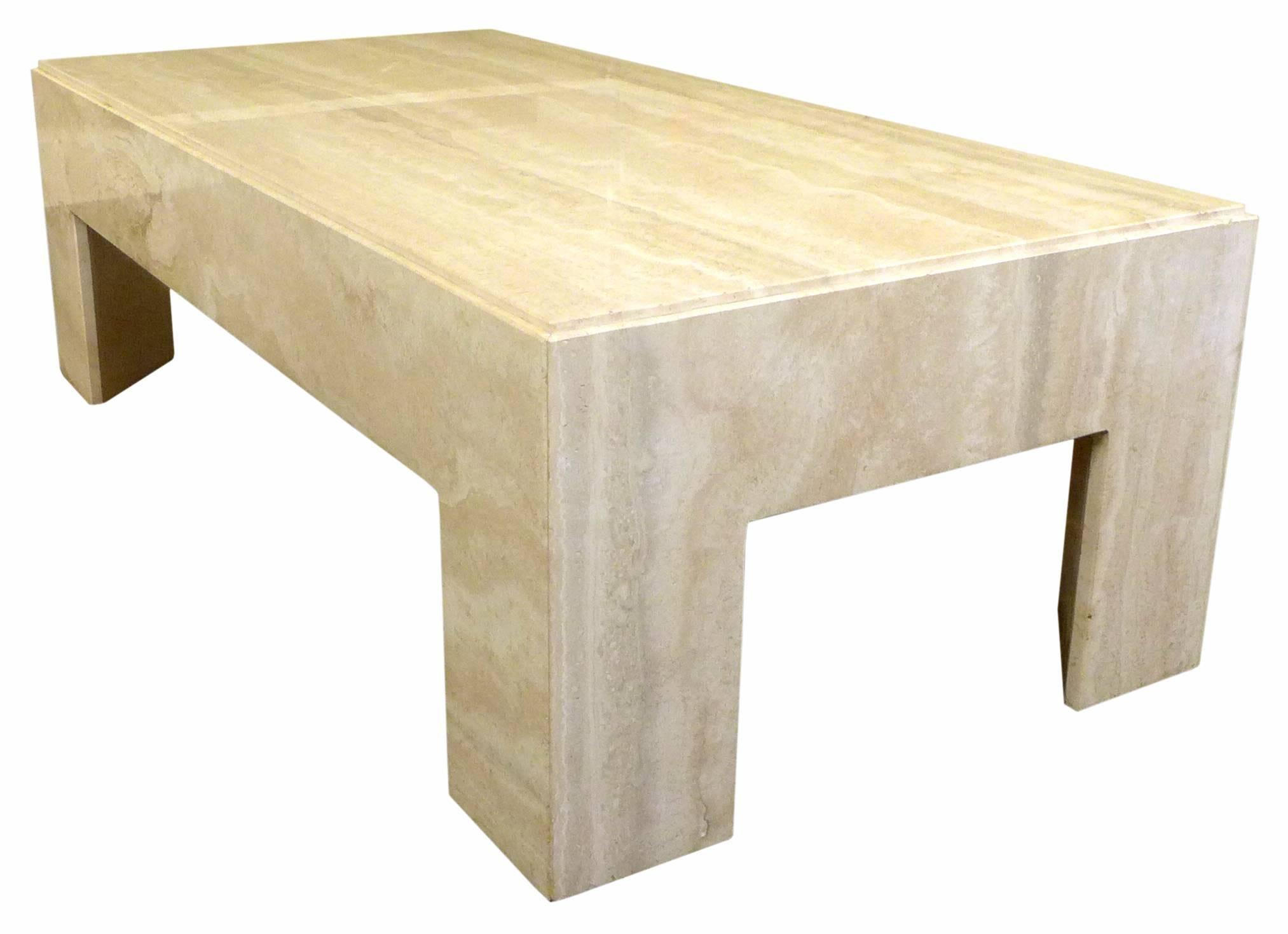 A fantastic travertine coffee table. An incredible form of great proportion and unexpected detail. Though hollow underneath, mitered travertine slabs built to imply one massive structure with prismatic legs and a decorative groove along the top