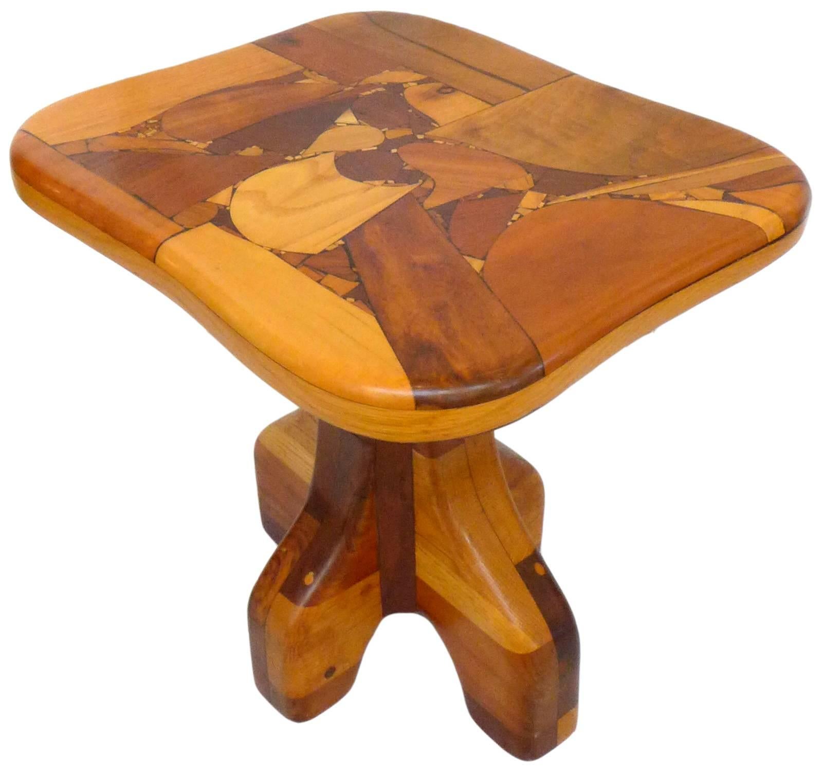 An extraordinary pair of handcrafted, wood marquetry side tables. Beautifully, thoroughly constructed of eye-catching, contrasting woods throughout; fantastic, abstract marquetry table tops with subtly curving edges sit atop four-footed pedestal